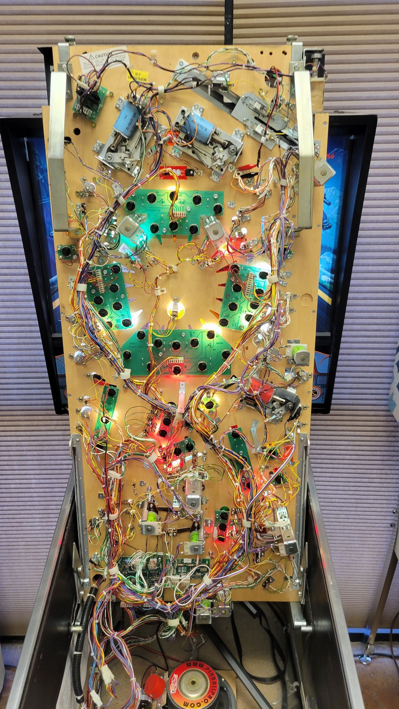 A pinball machine with a lot of wires coming out of it.