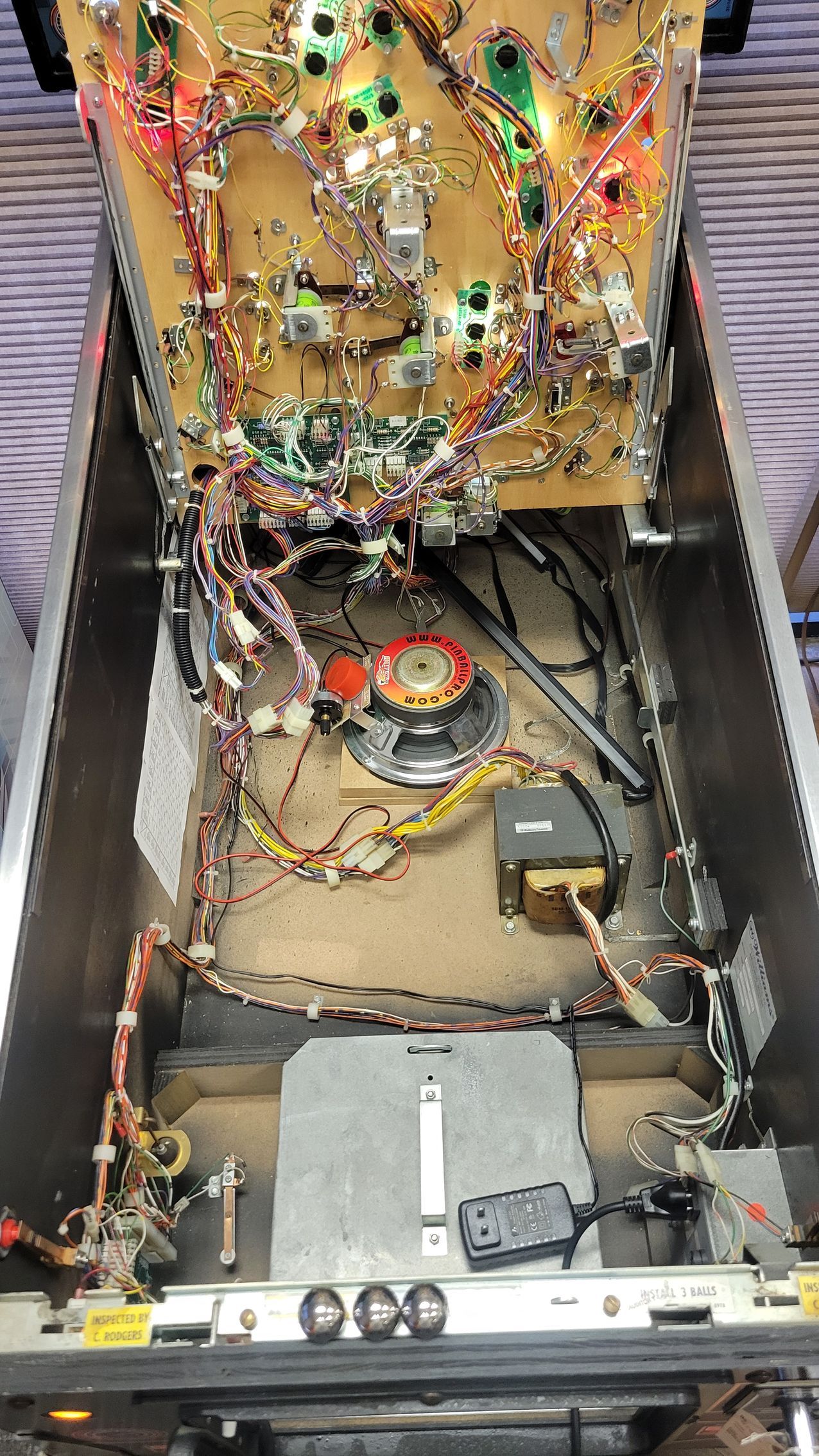 The inside of a pinball machine with a lot of wires coming out of it.