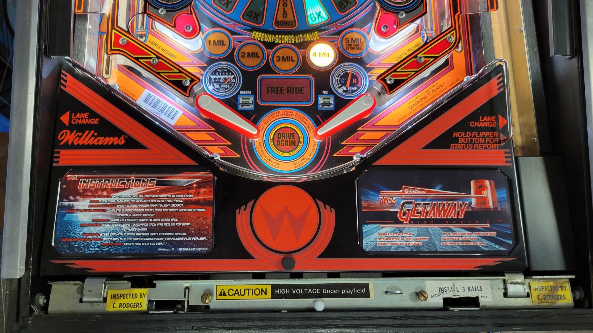 A pinball machine with a caution sign on it