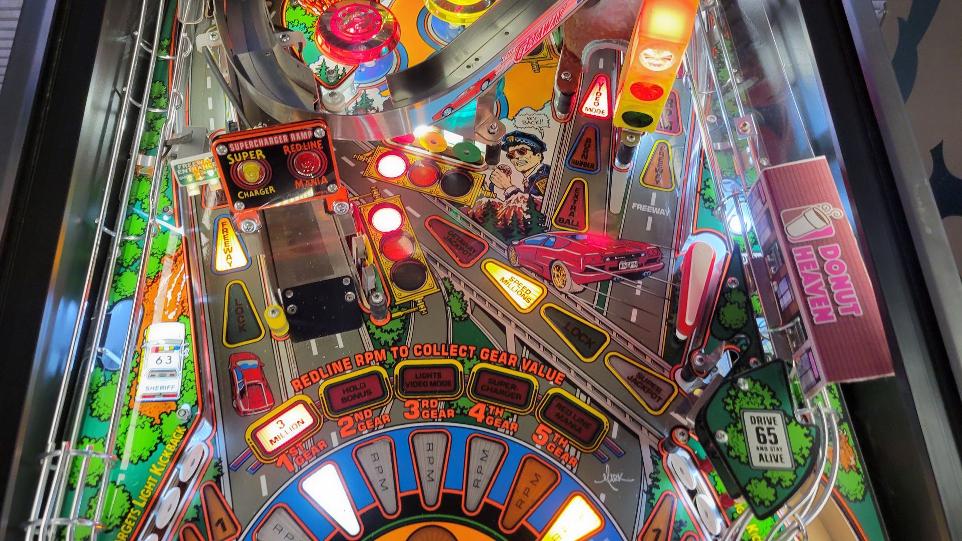 A close up of a pinball machine with a street scene on it.