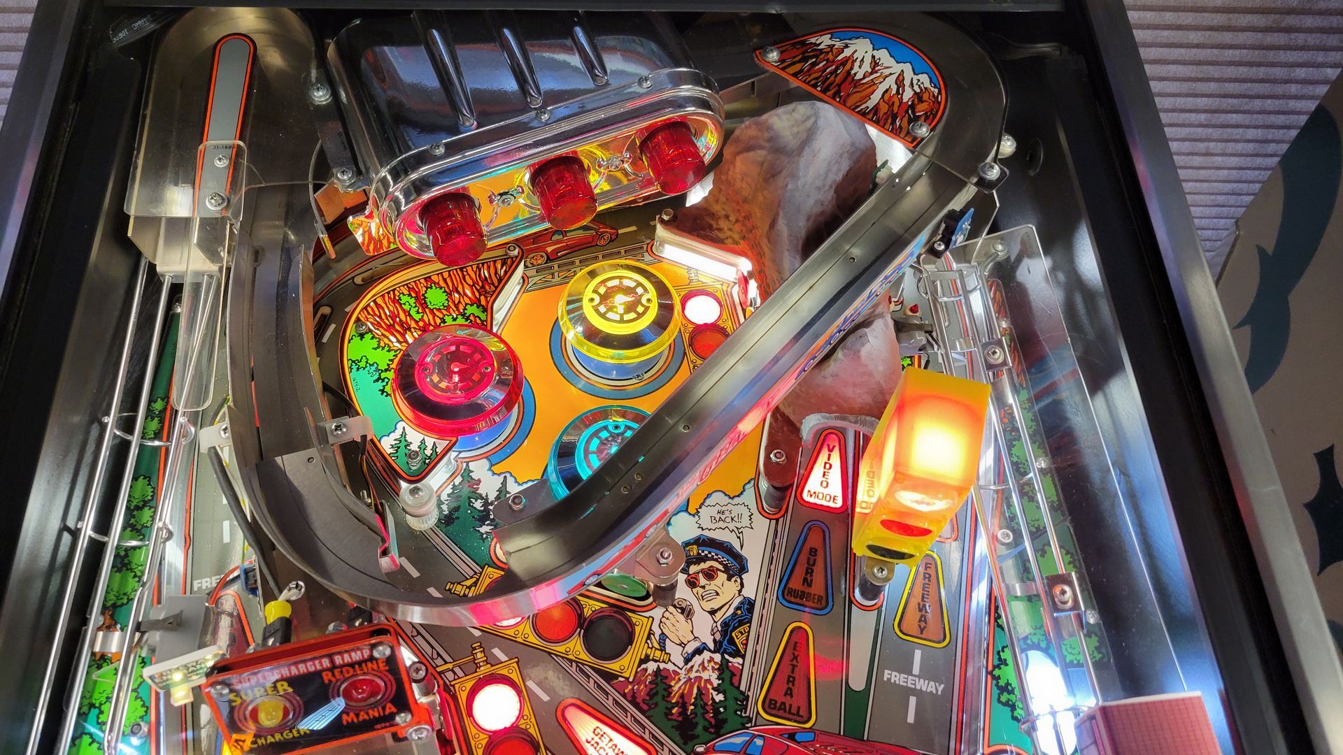 A close up of a pinball machine with a lot of lights on it.