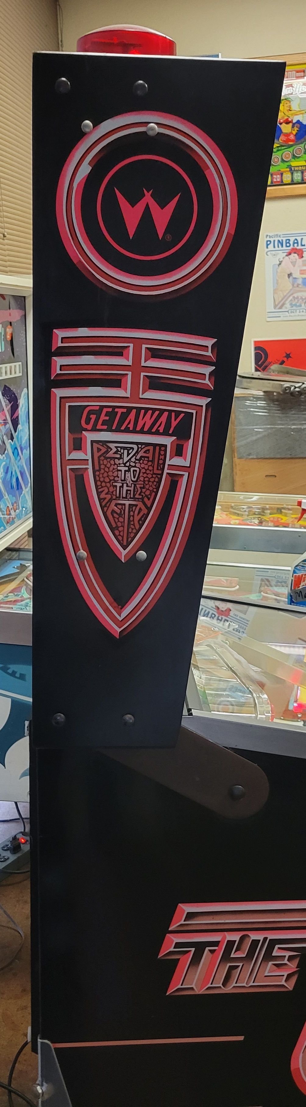 A black arcade machine with a red logo on it.