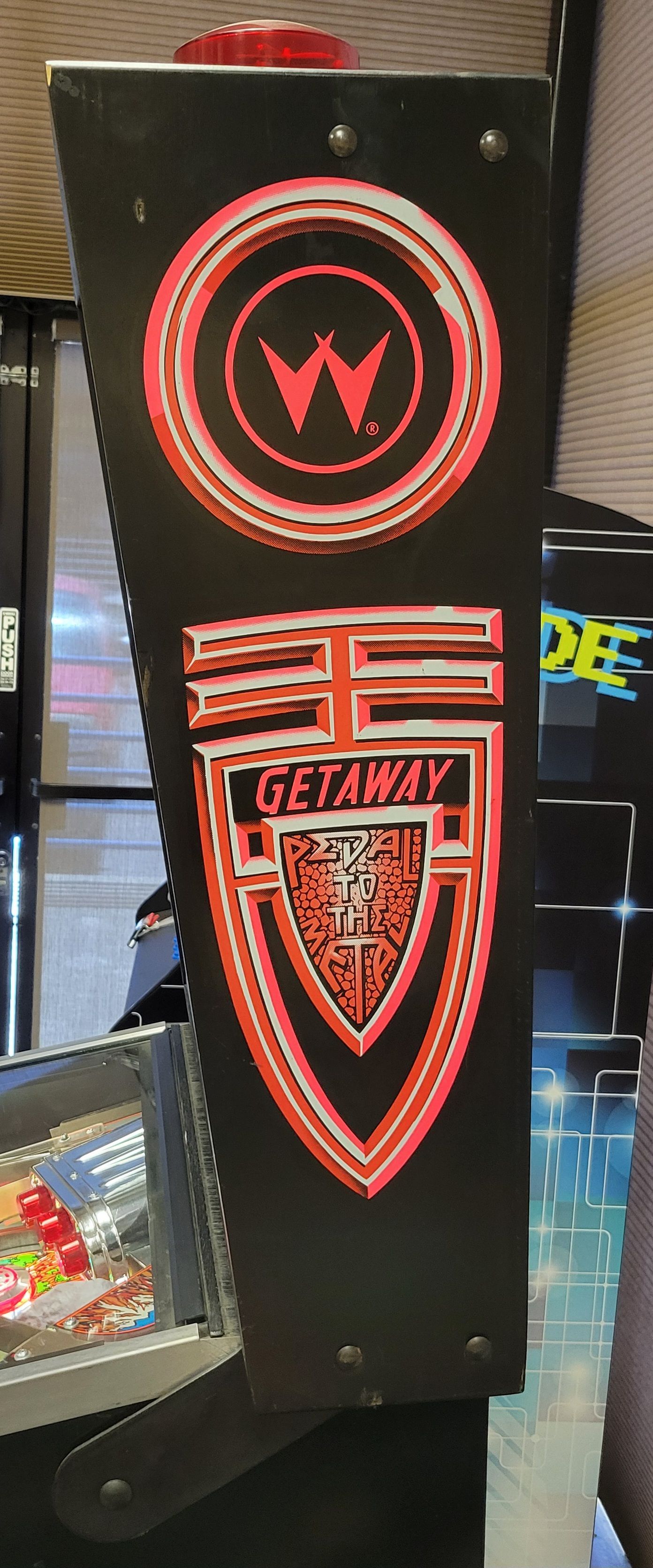 A close up of a pinball machine with a logo on it.