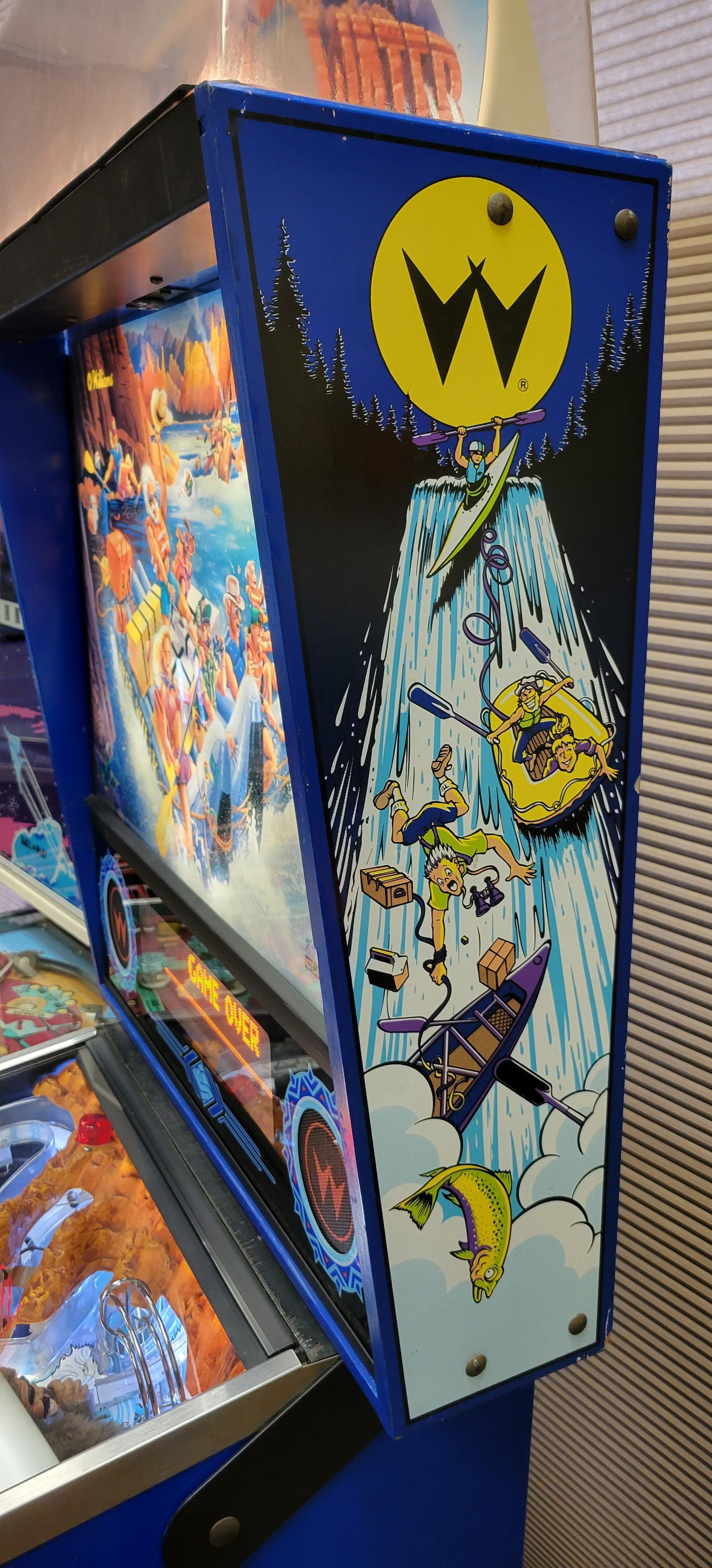 A pinball machine with a waterfall on the side of it.