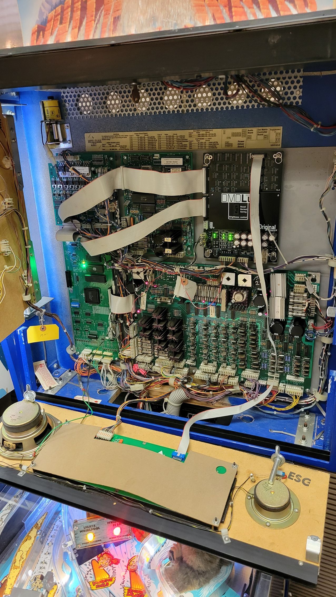 The inside of a pinball machine with a lot of wires coming out of it.
