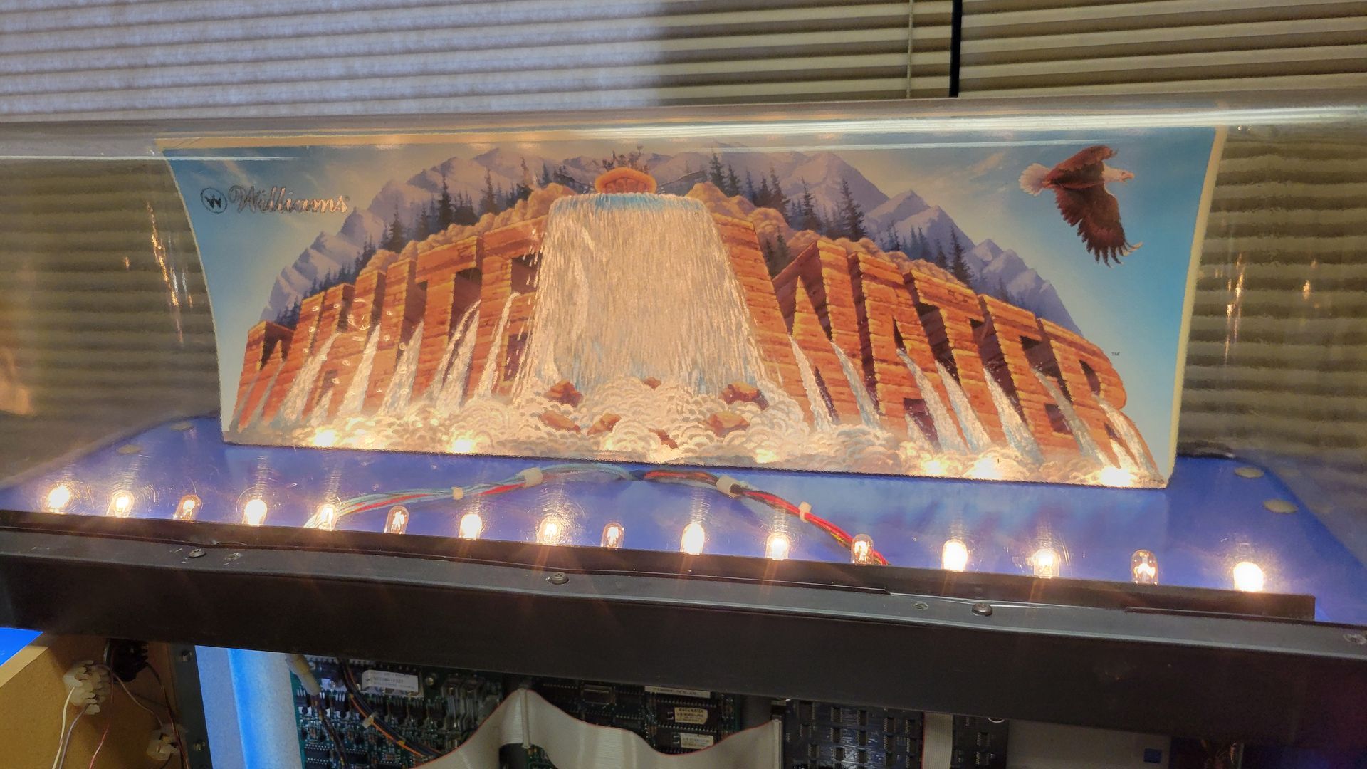 A painting of a mountain is sitting on a table with lights on it.
