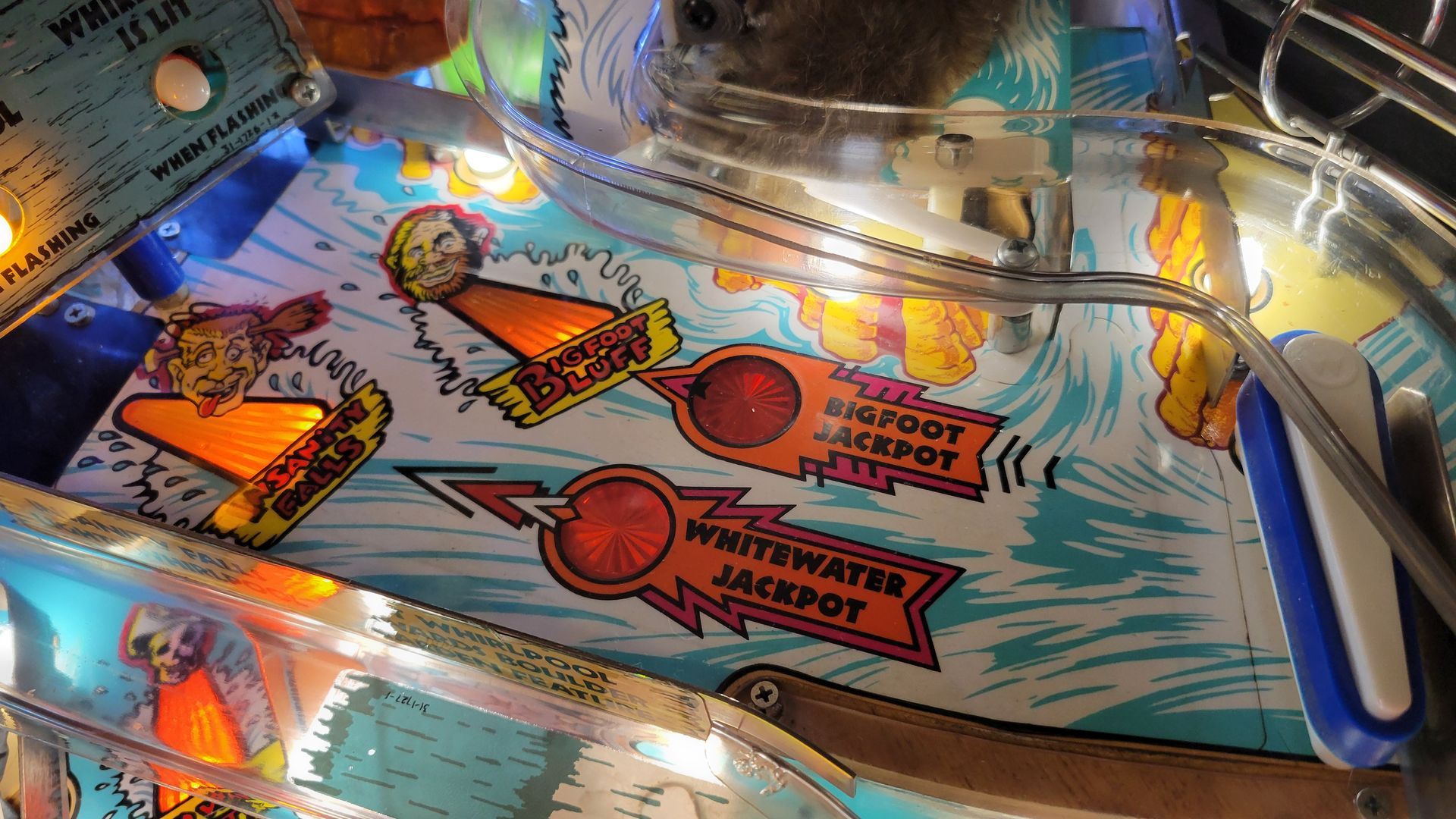A close up of a pinball machine that says whitewater jackpot