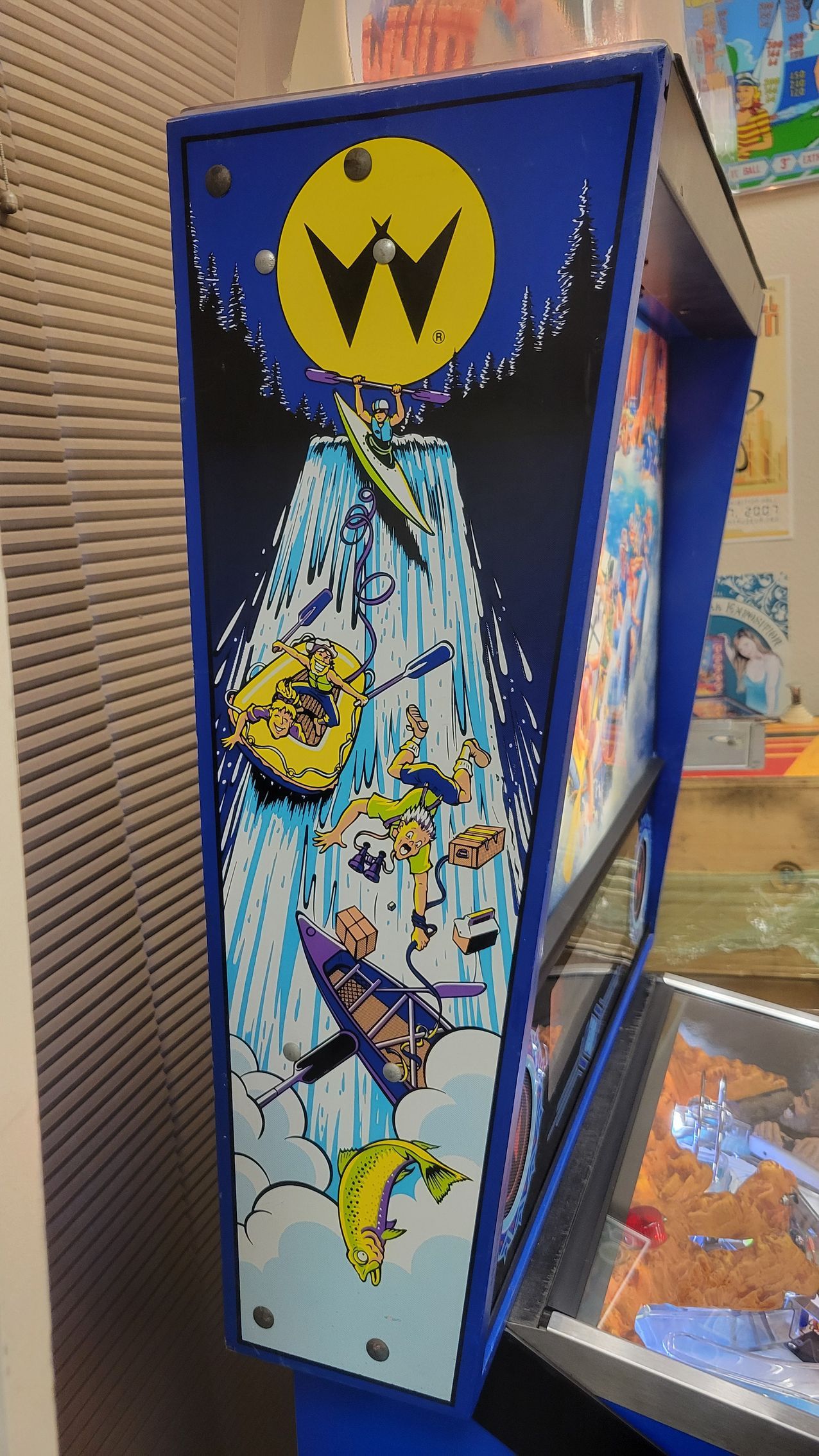 A pinball machine with a waterfall on the side of it.