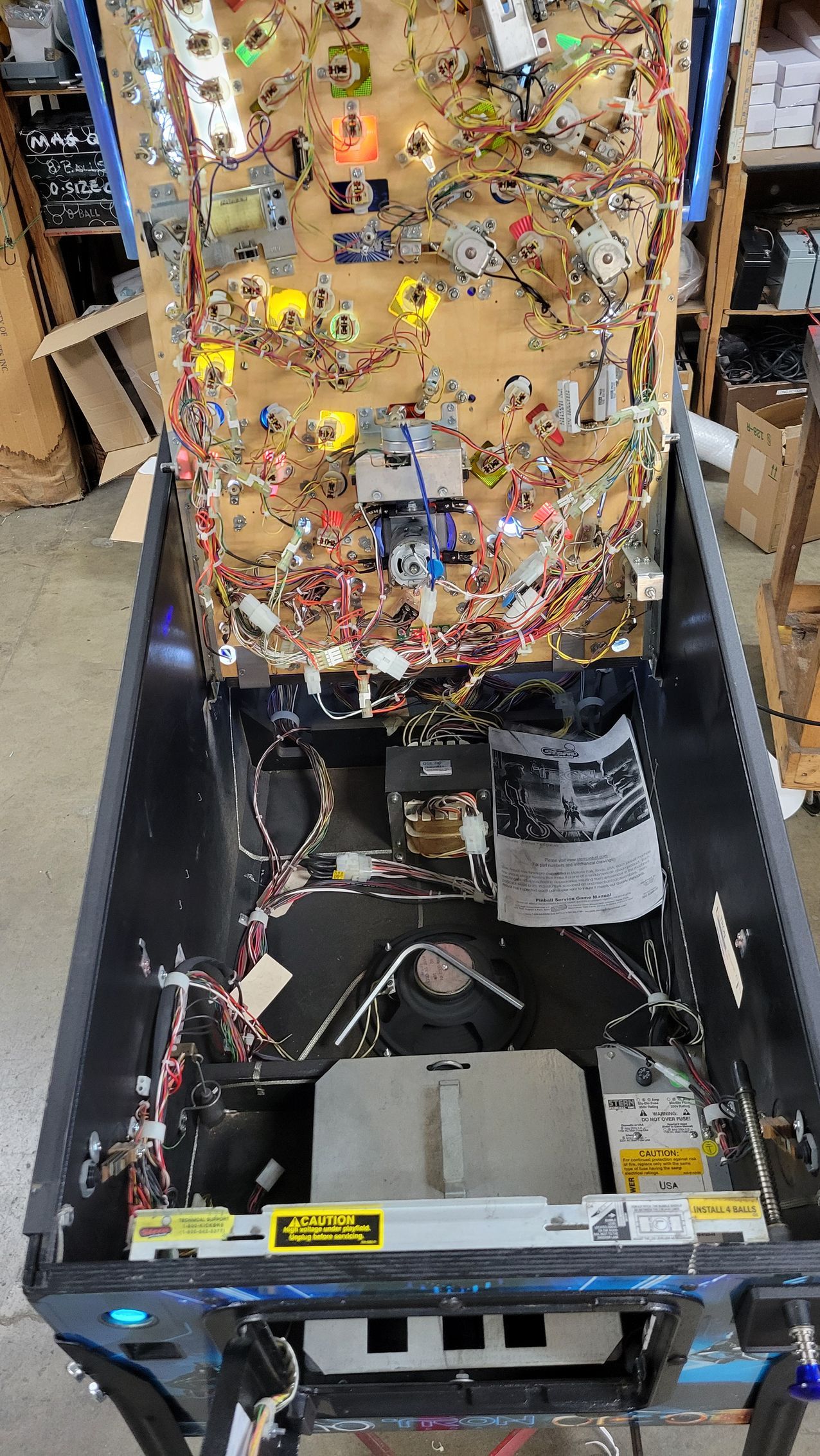 The inside of a pinball machine with a lot of wires coming out of it.