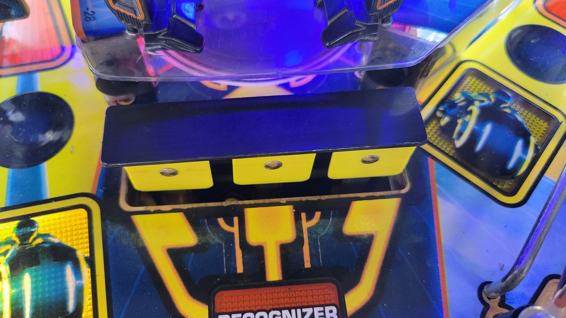 A close up of a pinball machine with a blue light behind it.