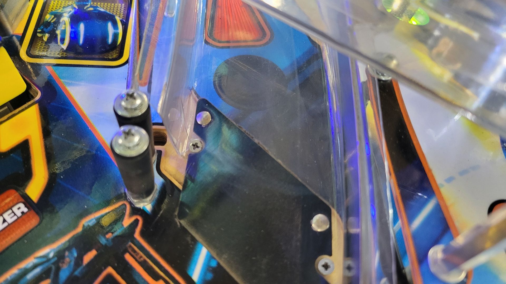A close up of a pinball machine with a skateboard on it.