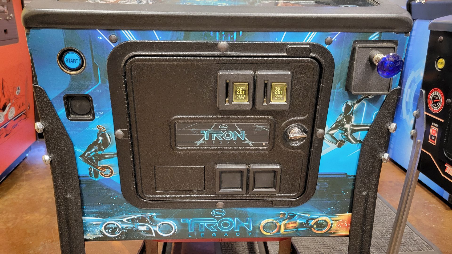 A tron pinball machine is sitting on a table in a room.