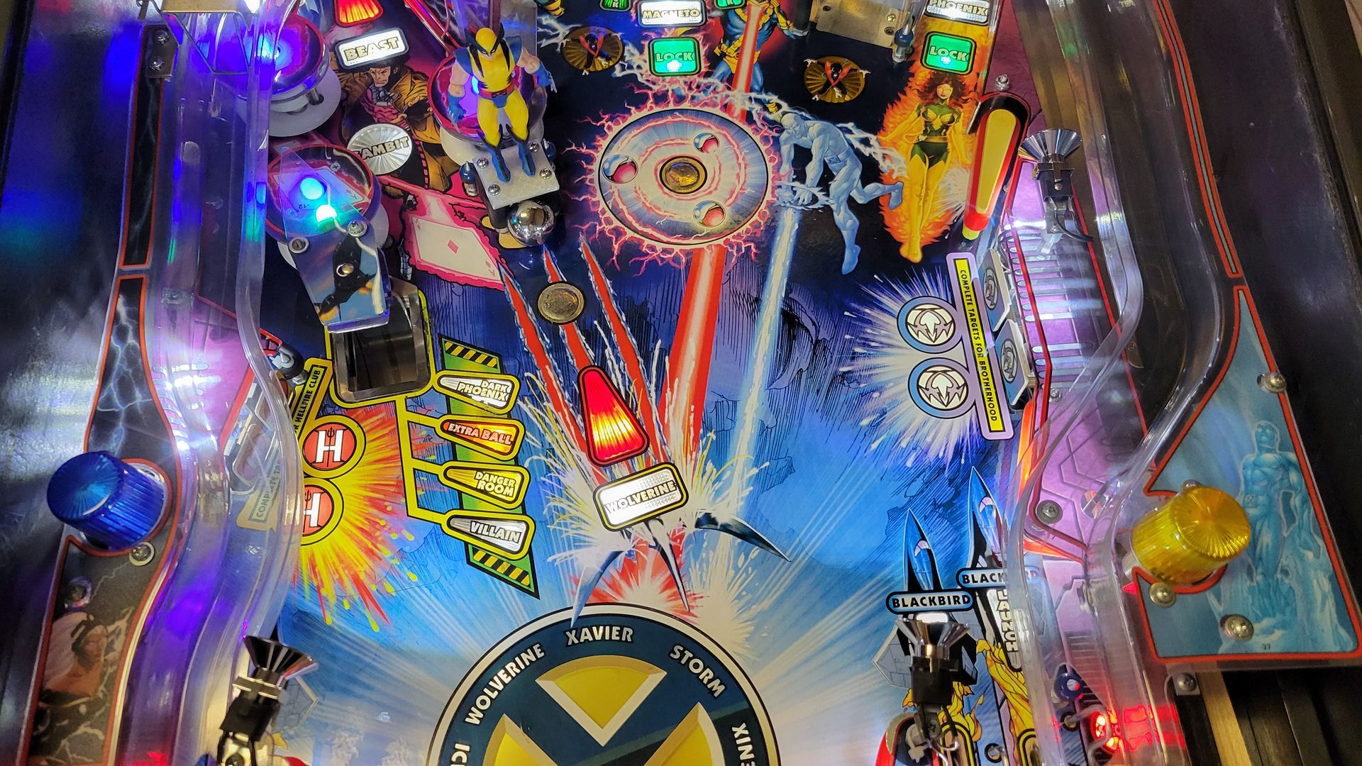 A pinball machine with a x-men logo on it.