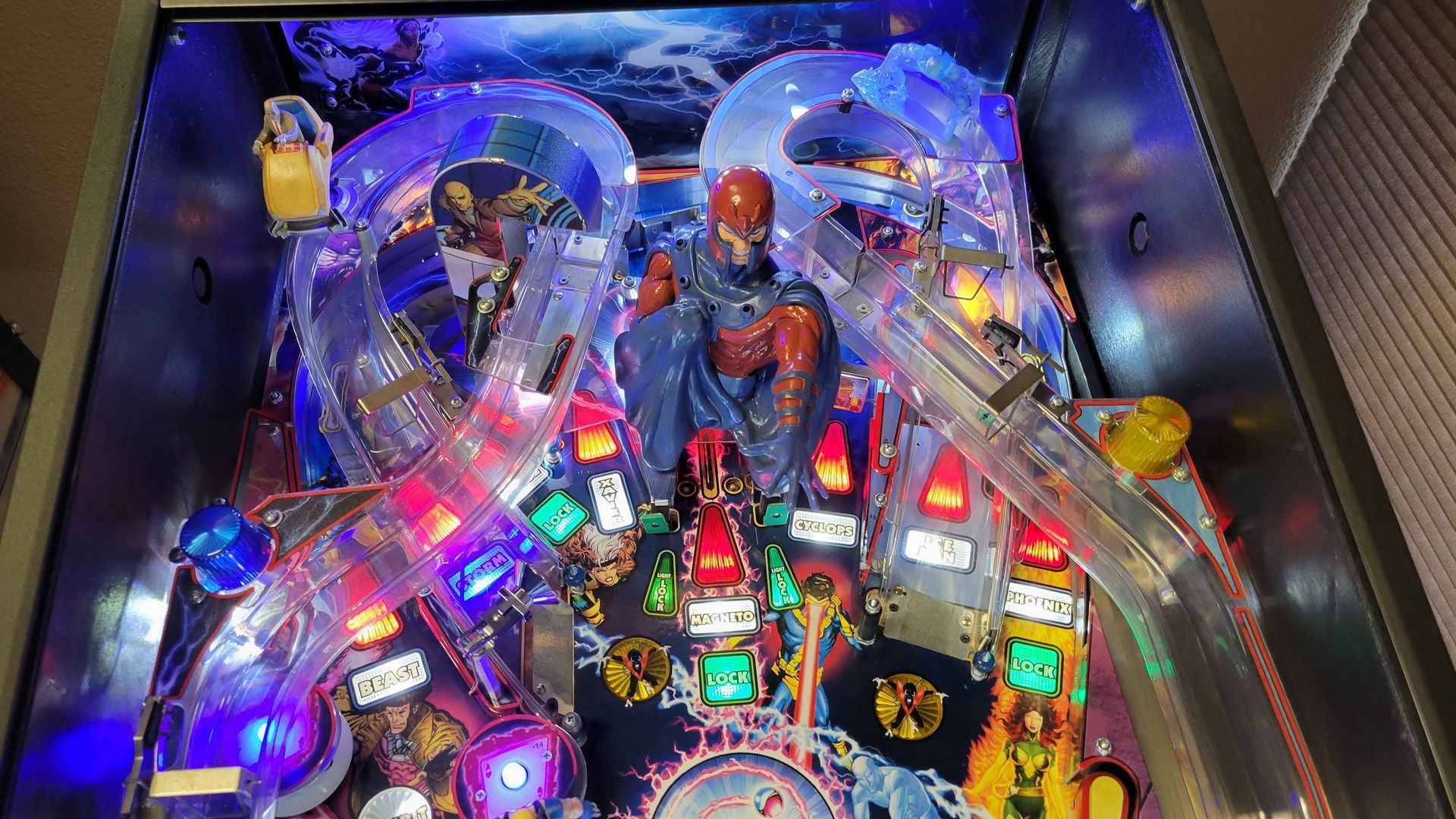 A pinball machine with a man sitting on top of it.