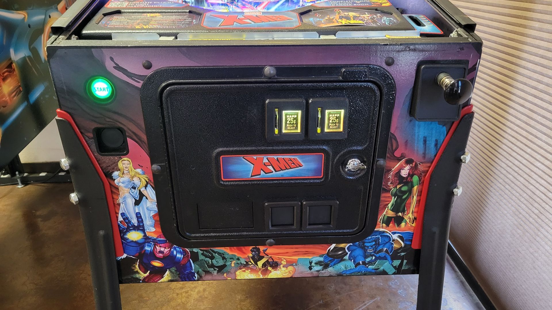 A pinball machine with a green light on it is sitting on a table.