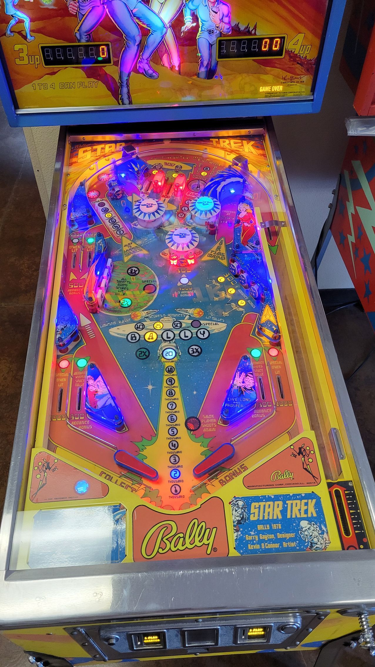A pinball machine is sitting on top of a wooden table.