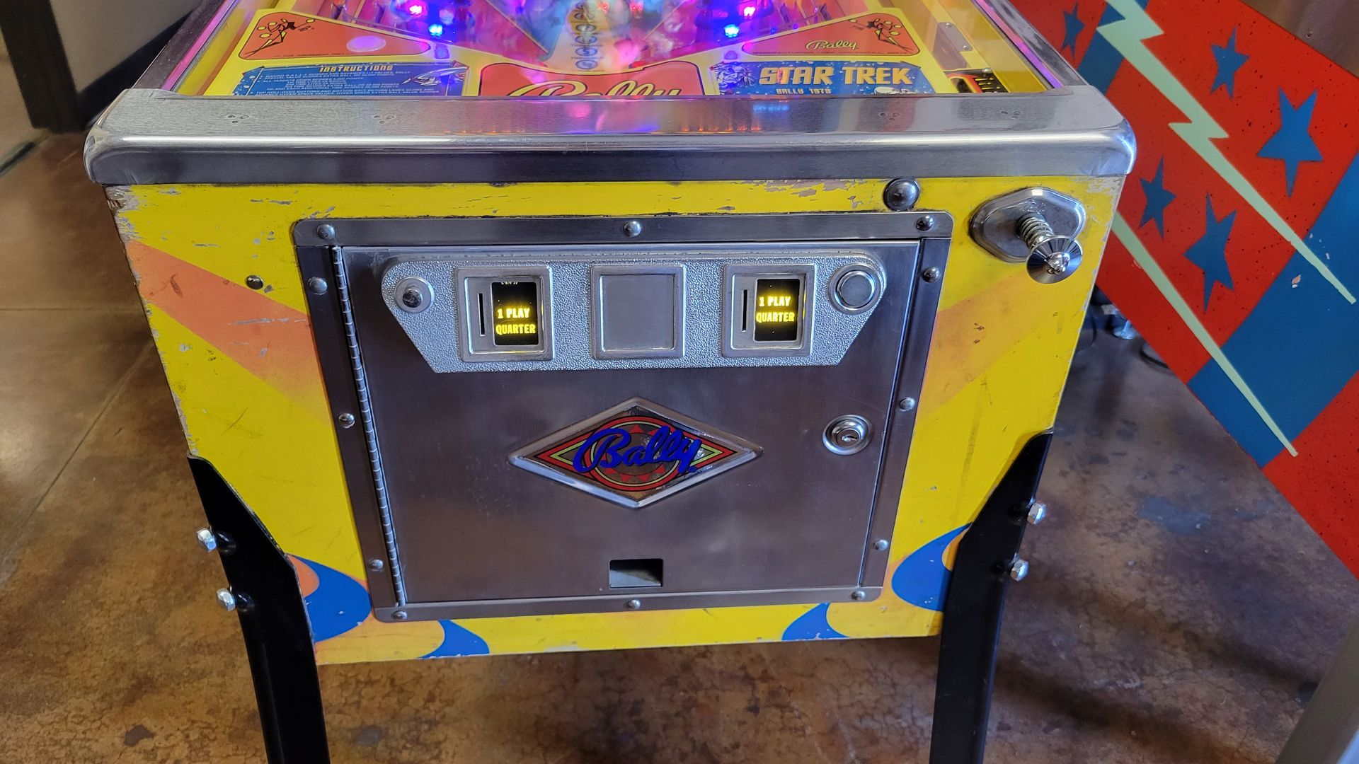 A pinball machine is sitting on a wooden floor.