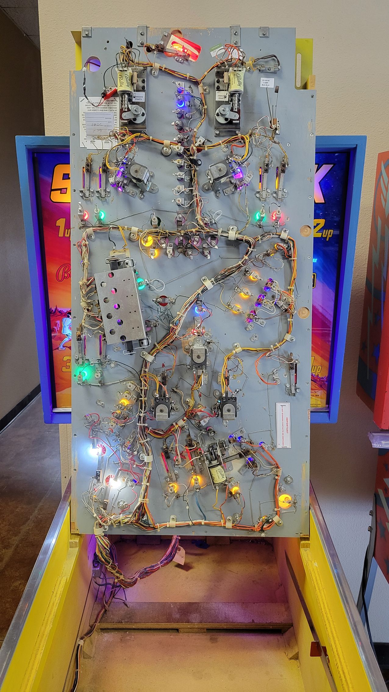A close up of a pinball machine with a lot of lights on it.
