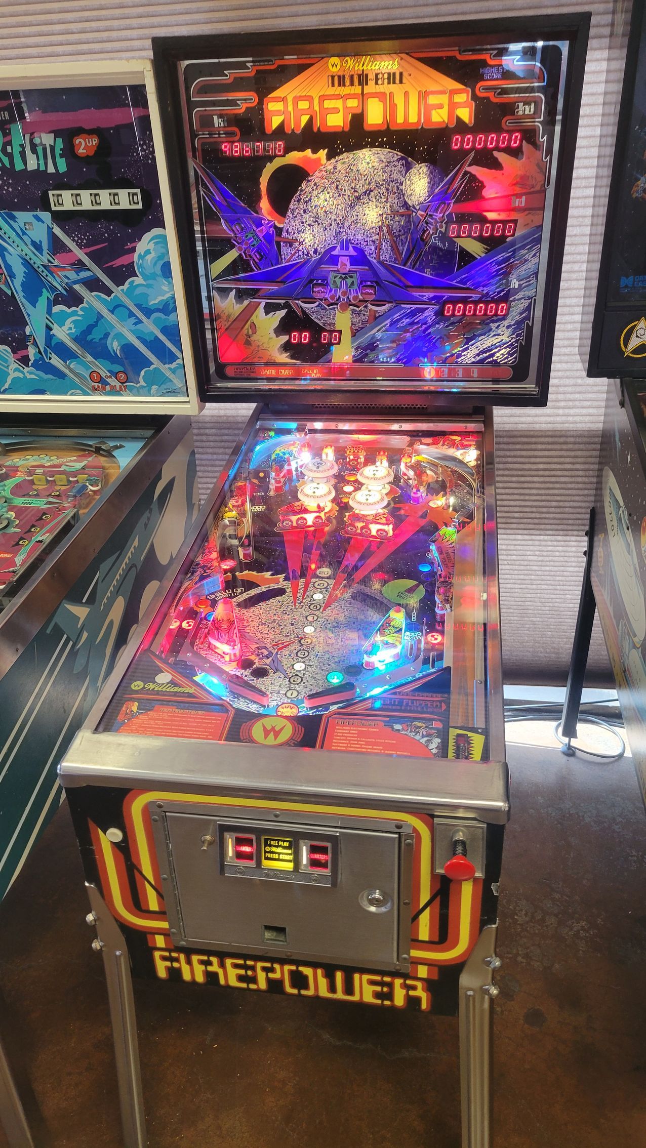 A pinball machine is sitting on a table in a room.