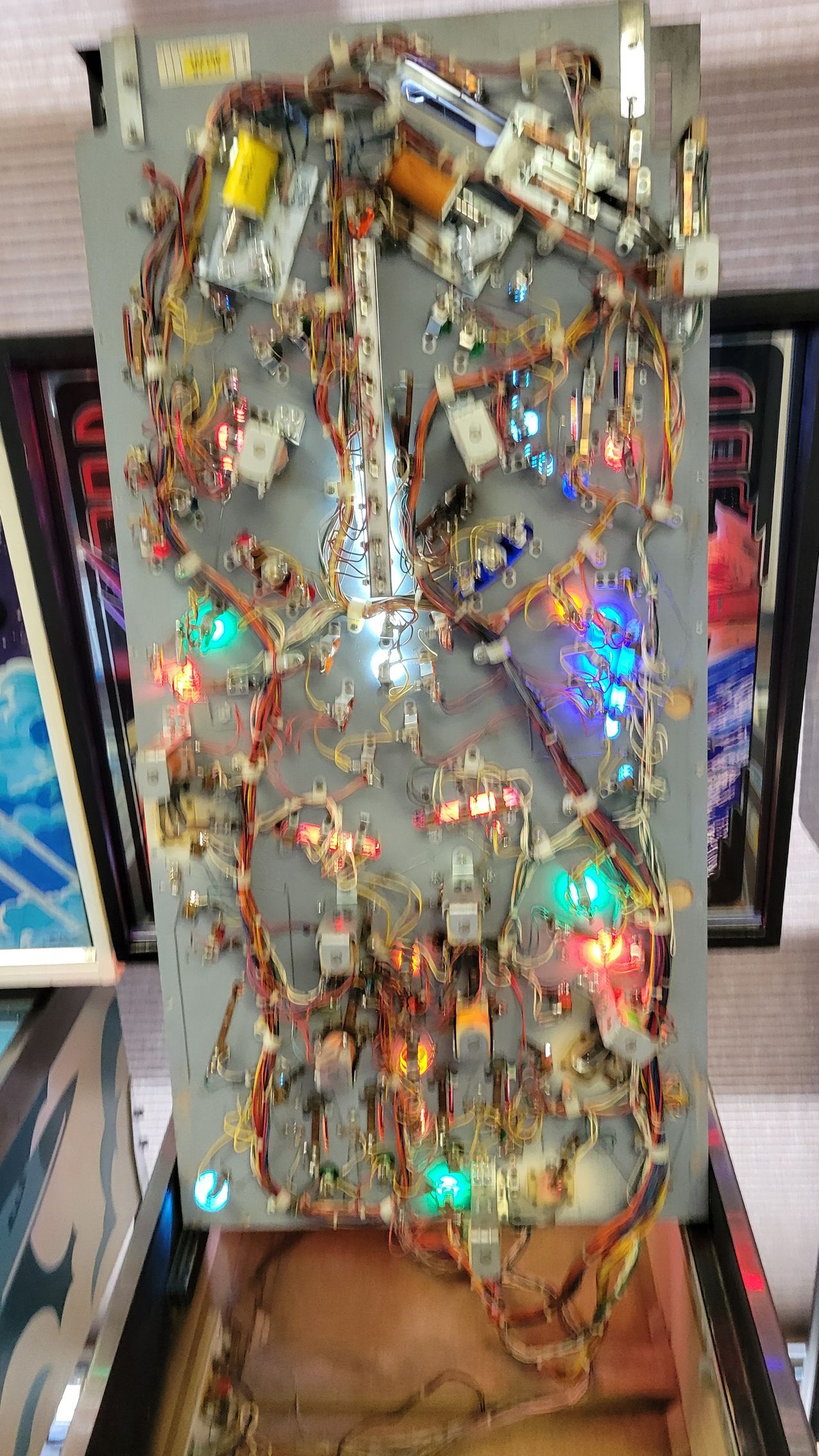 A pinball machine with a lot of wires and lights on it.