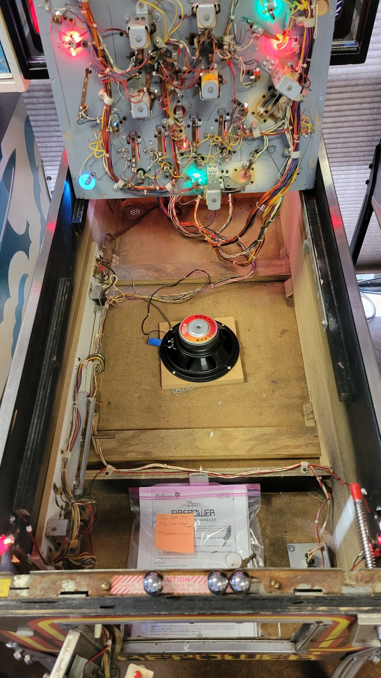 The inside of a pinball machine with a record on top of it.