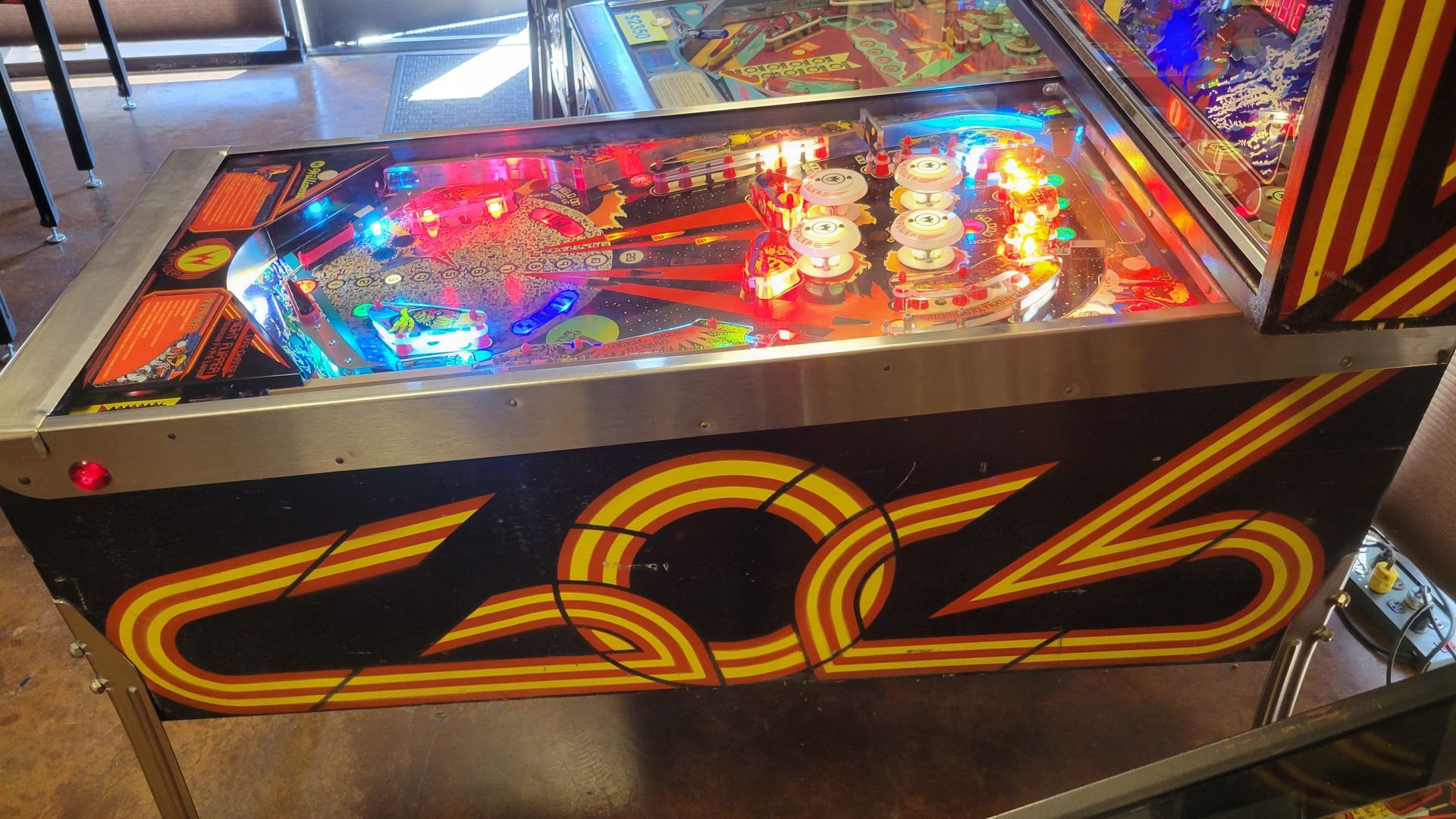 A pinball machine is sitting on a table in a room.