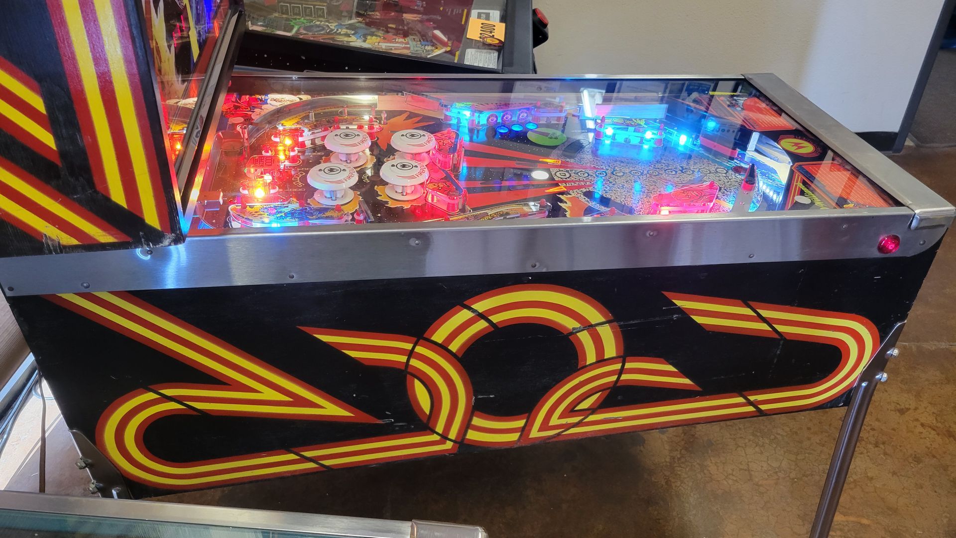 A pinball machine is sitting on the floor in a room.