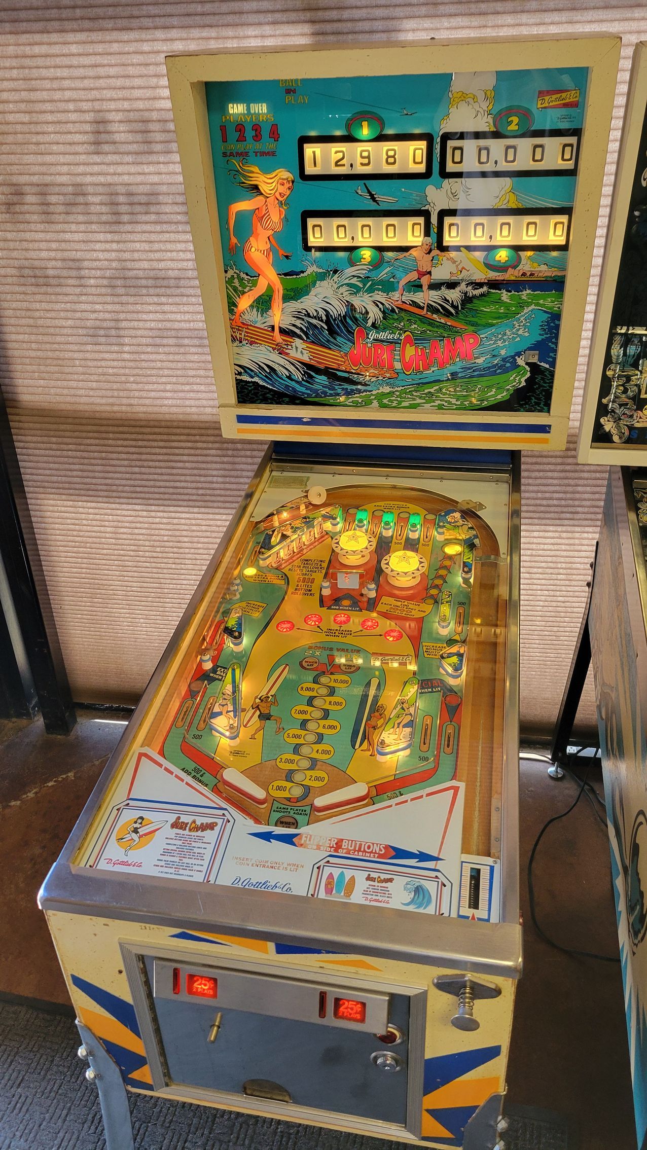 A pinball machine is sitting on the floor in a room.