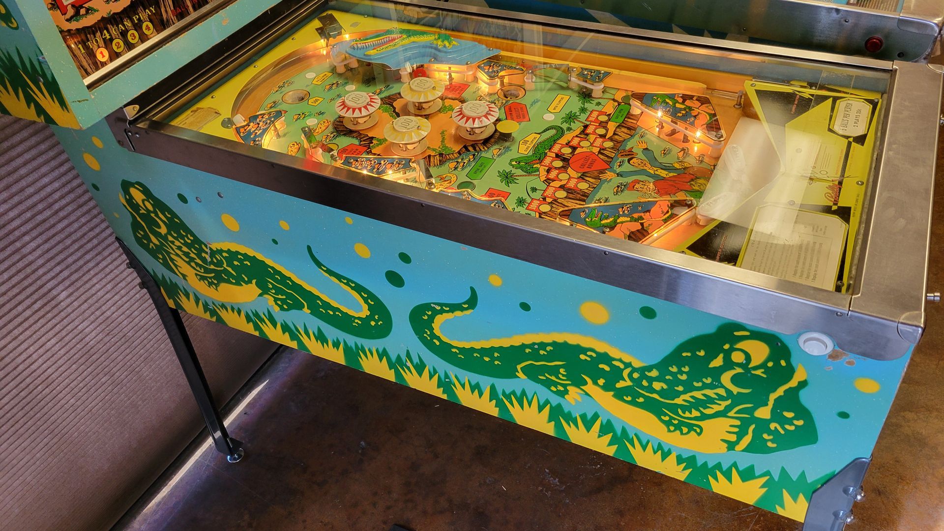 A pinball machine with a crocodile on the side