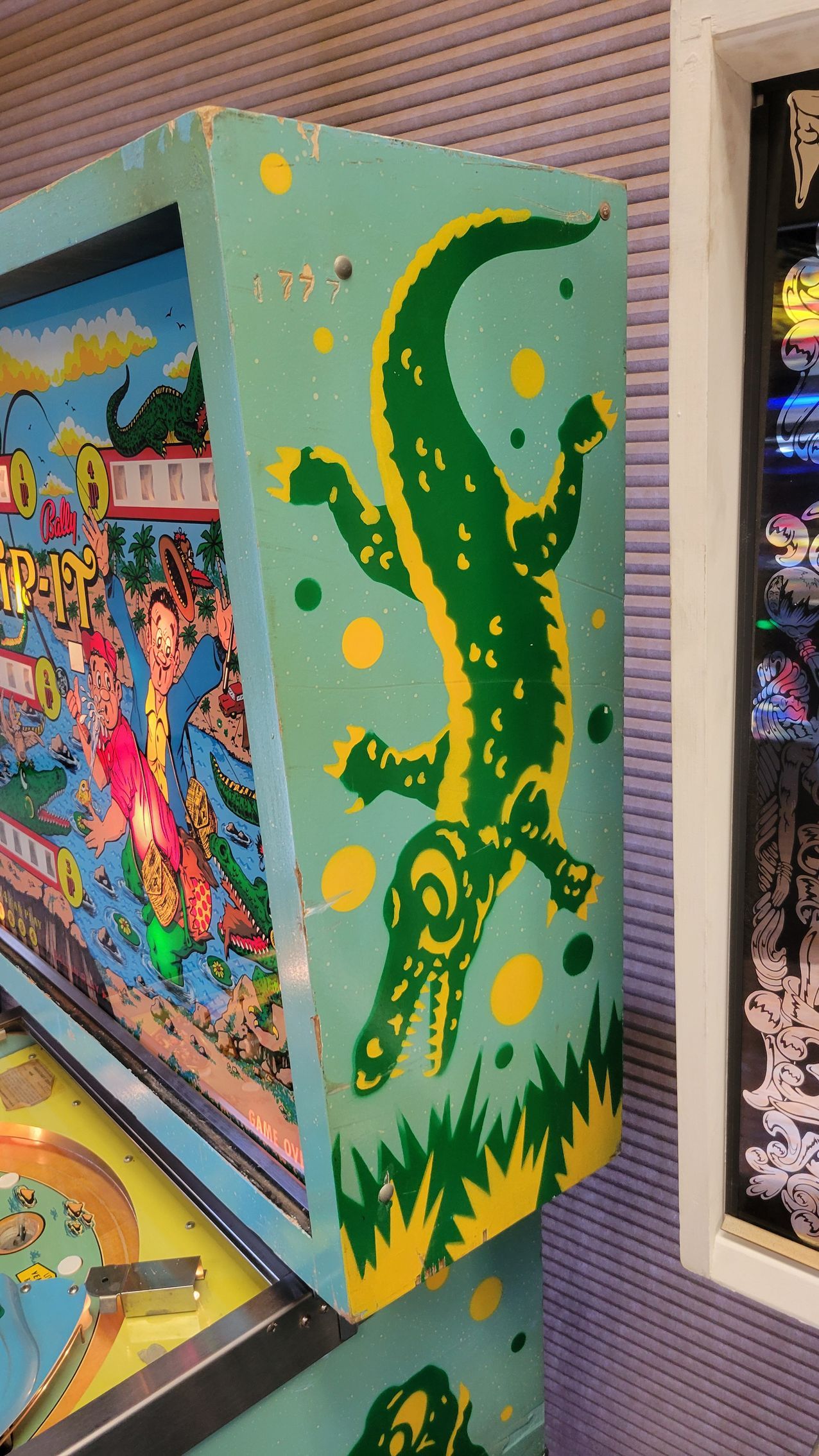 A pinball machine with a crocodile on the side of it.