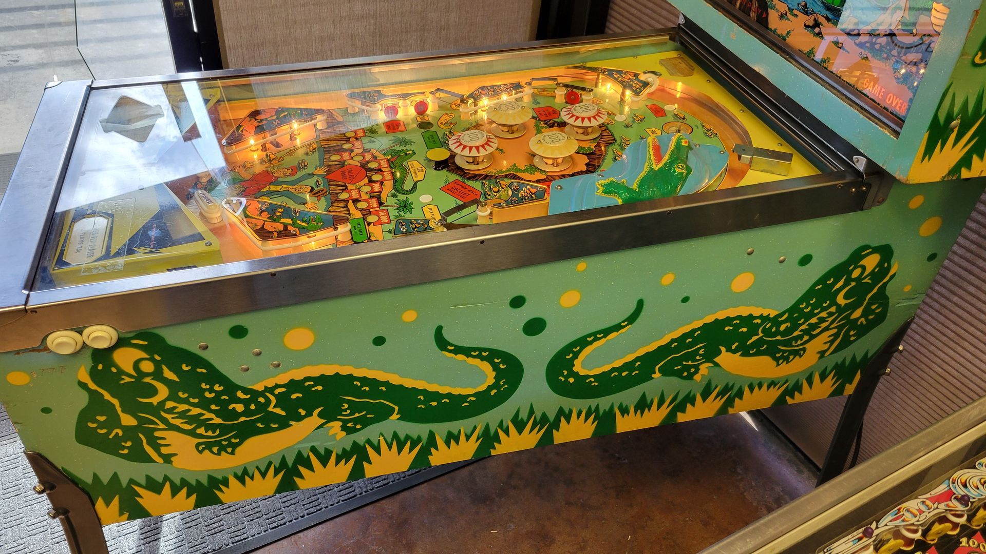 A pinball machine with a crocodile design on it