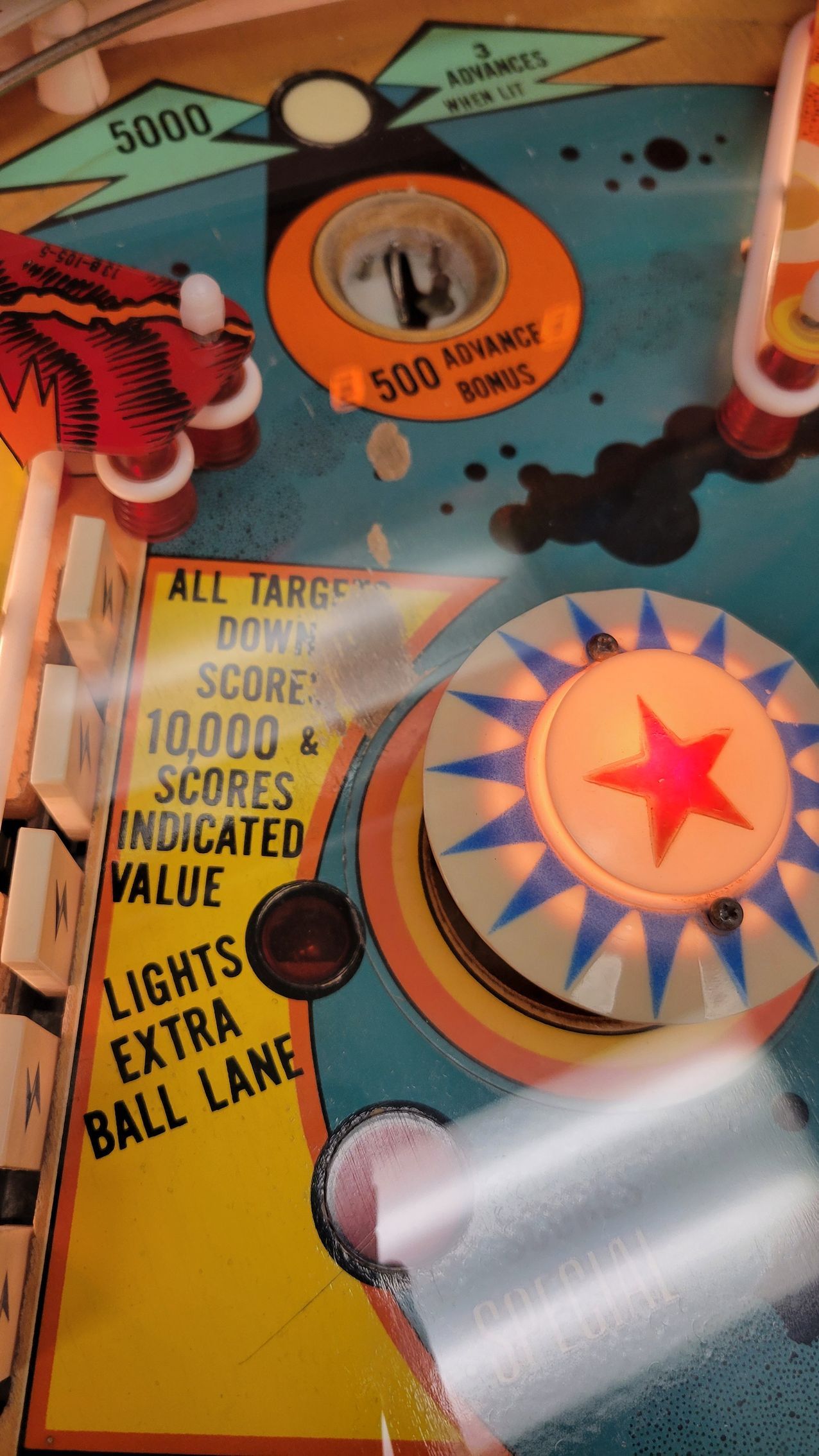 A close up of a pinball machine that says lights extra ball lane