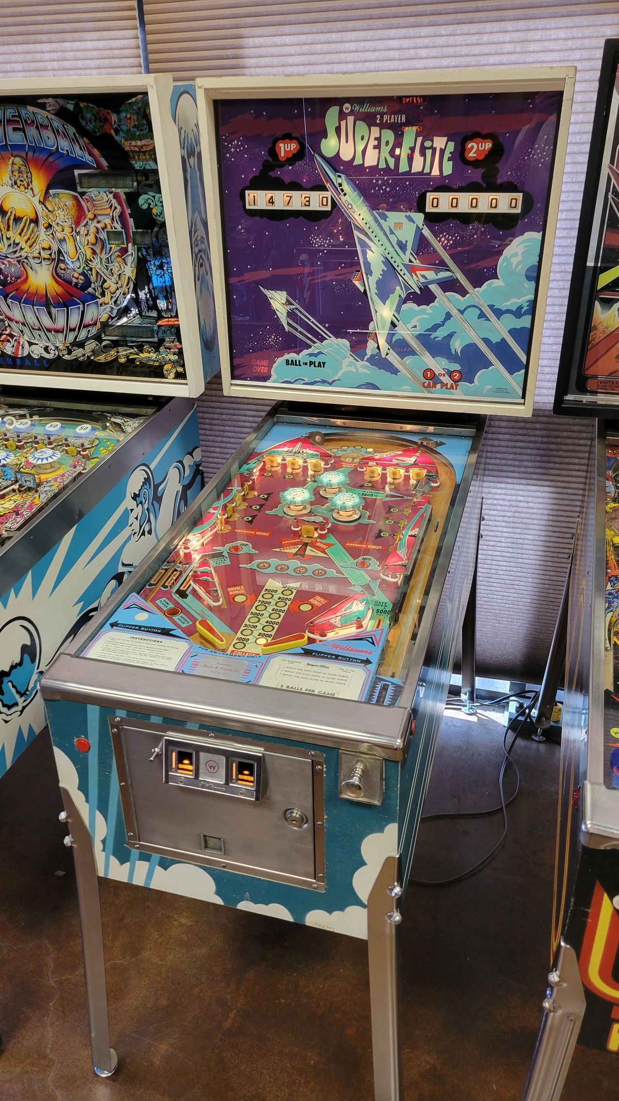 A pinball machine is sitting on a table in a room.