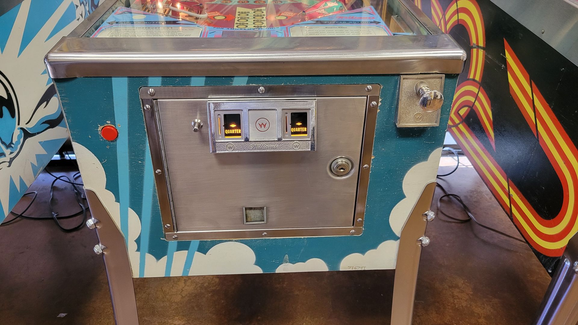 A pinball machine with a coin slot on the side of it.