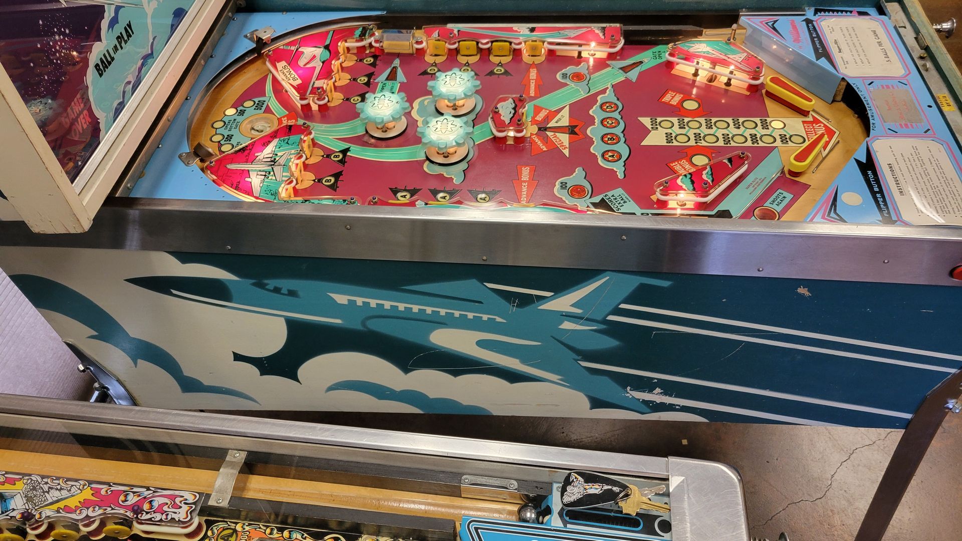 A pinball machine with a plane on it