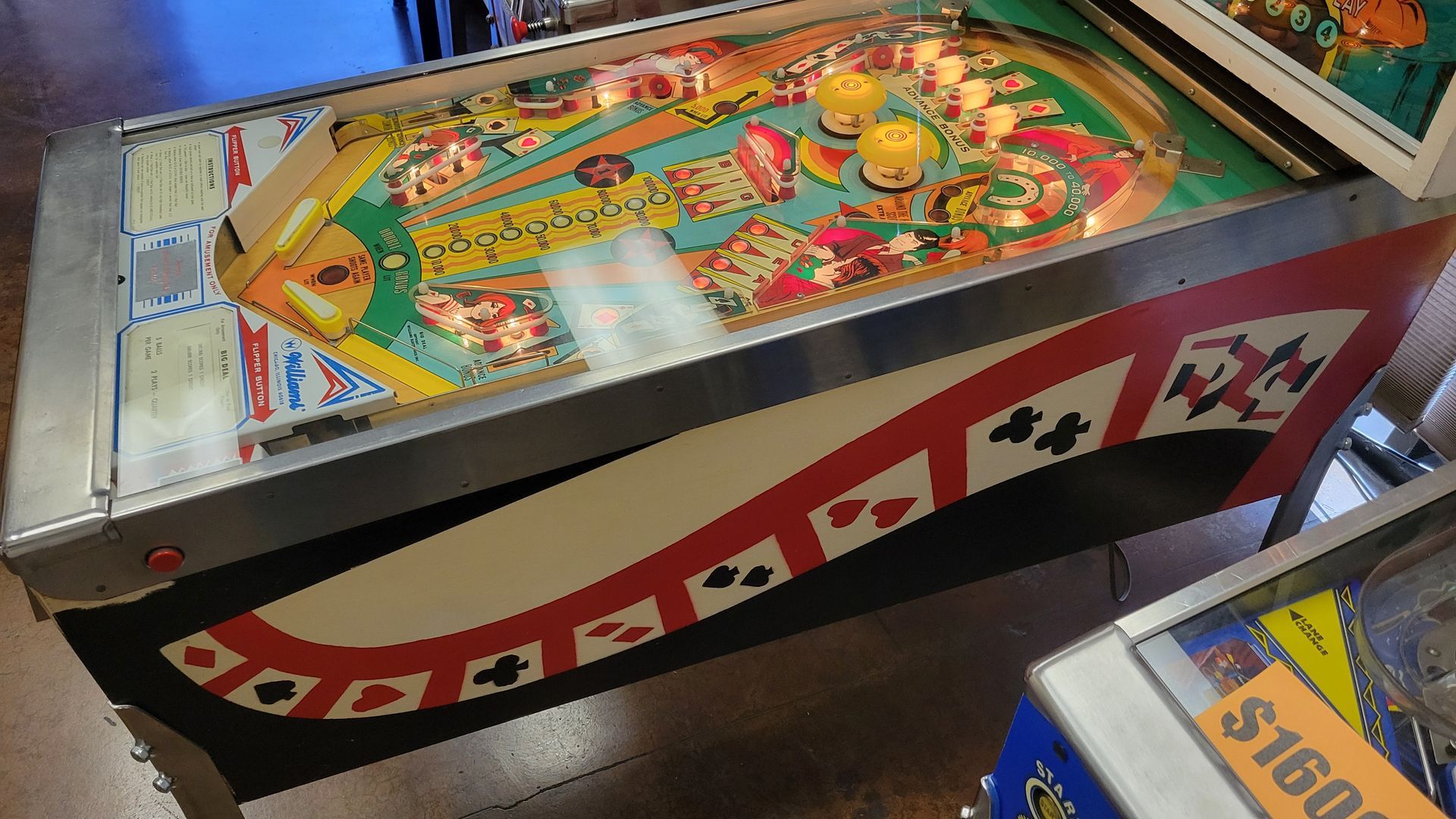 A pinball machine is sitting on the floor in a room.