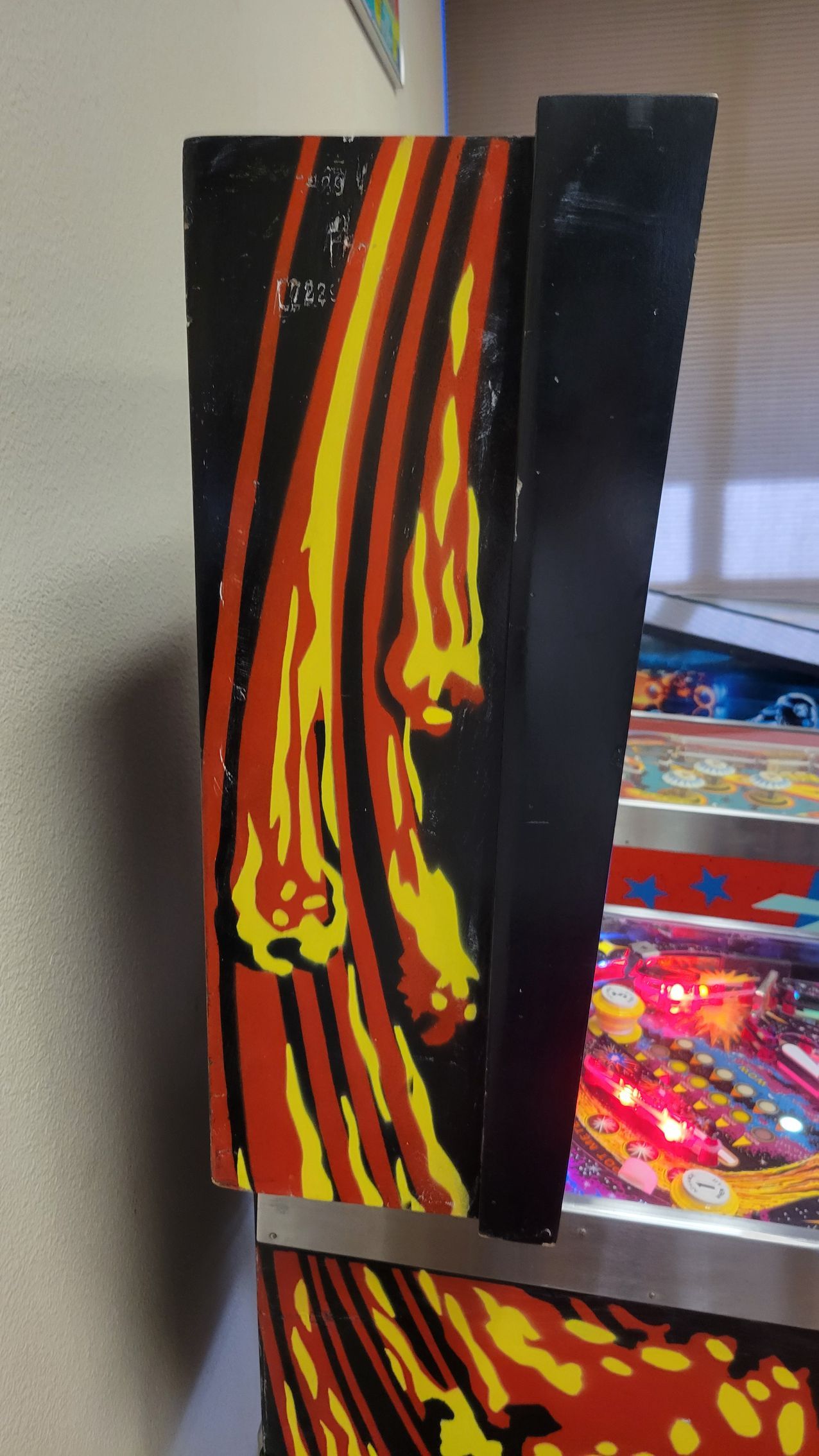 A pinball machine with flames on the side of it