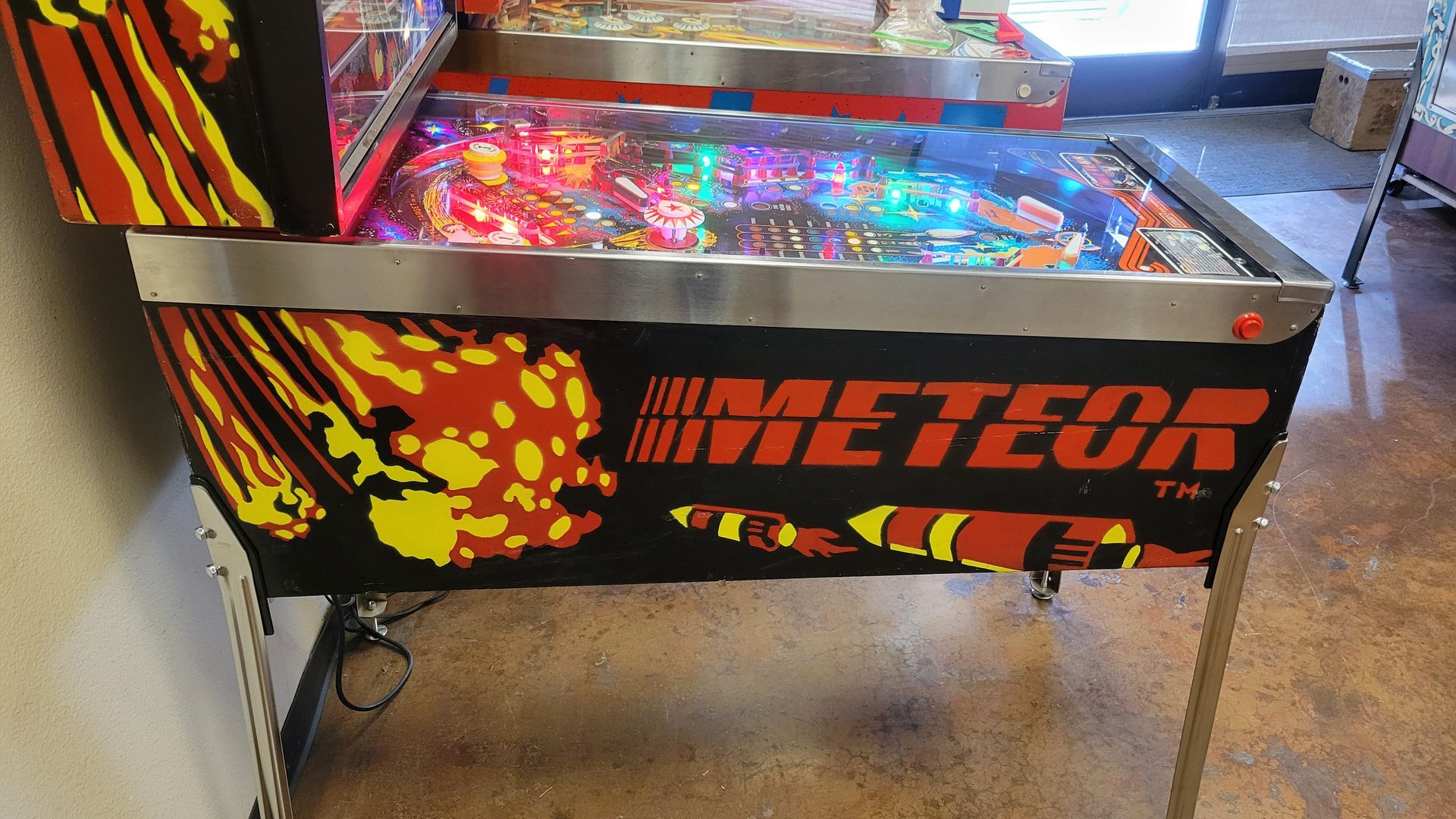A pinball machine with the word meteor on it