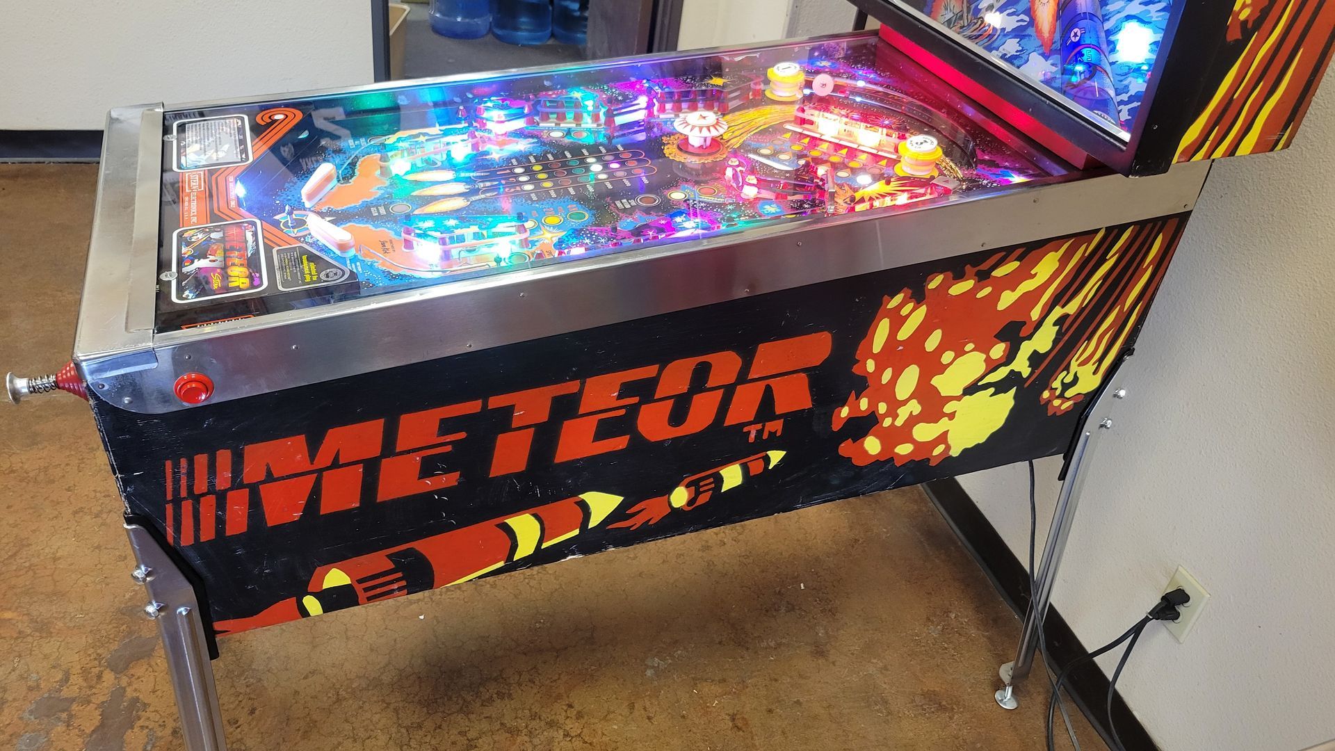 A pinball machine with the word meteor on it
