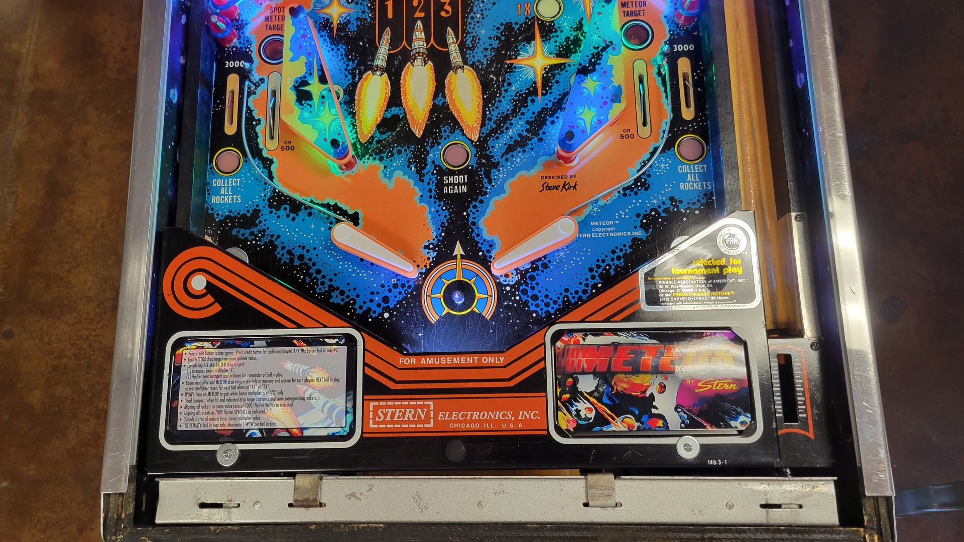 A pinball machine is sitting on a wooden table.