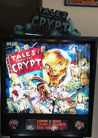 Tales from the crypt pinball machine is sitting on a table.