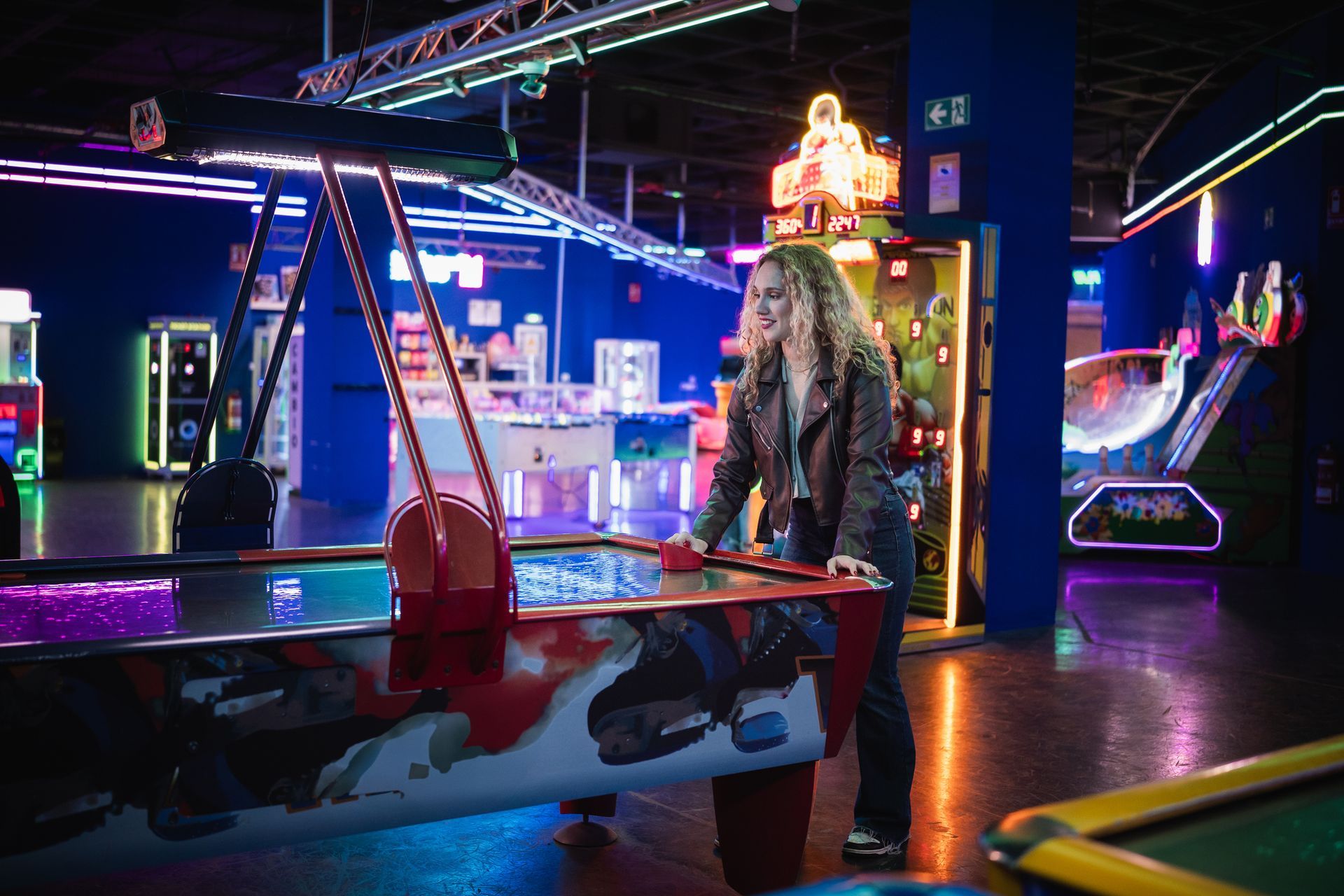 Woman playing air hockey in colorful arcade setting - Commercial Arcade Repairs In San Diego County