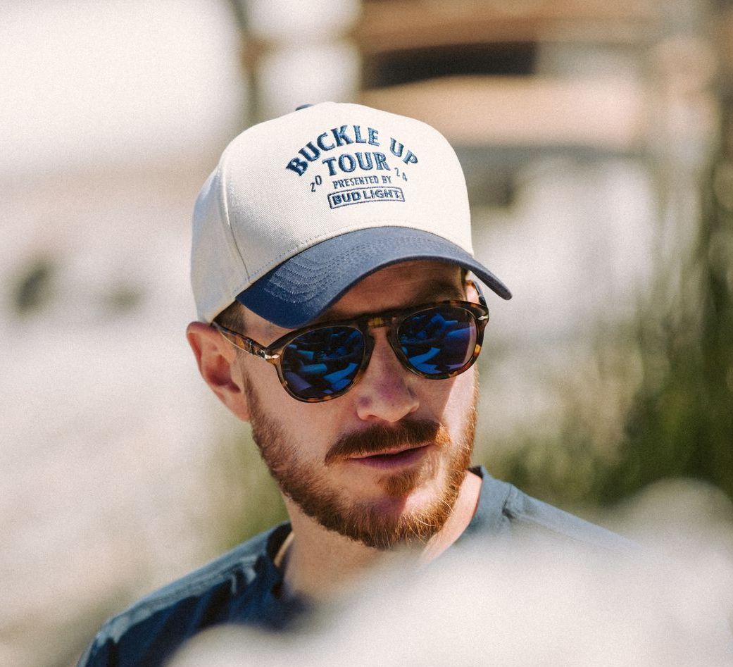 A man wearing a hat that says buckle up tour.