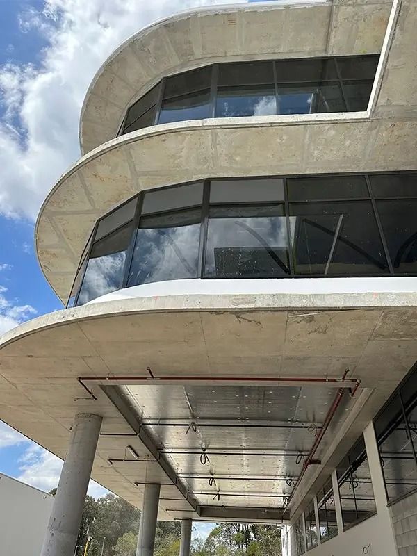 Three-story, circular concrete building with large windows and curved balconies.