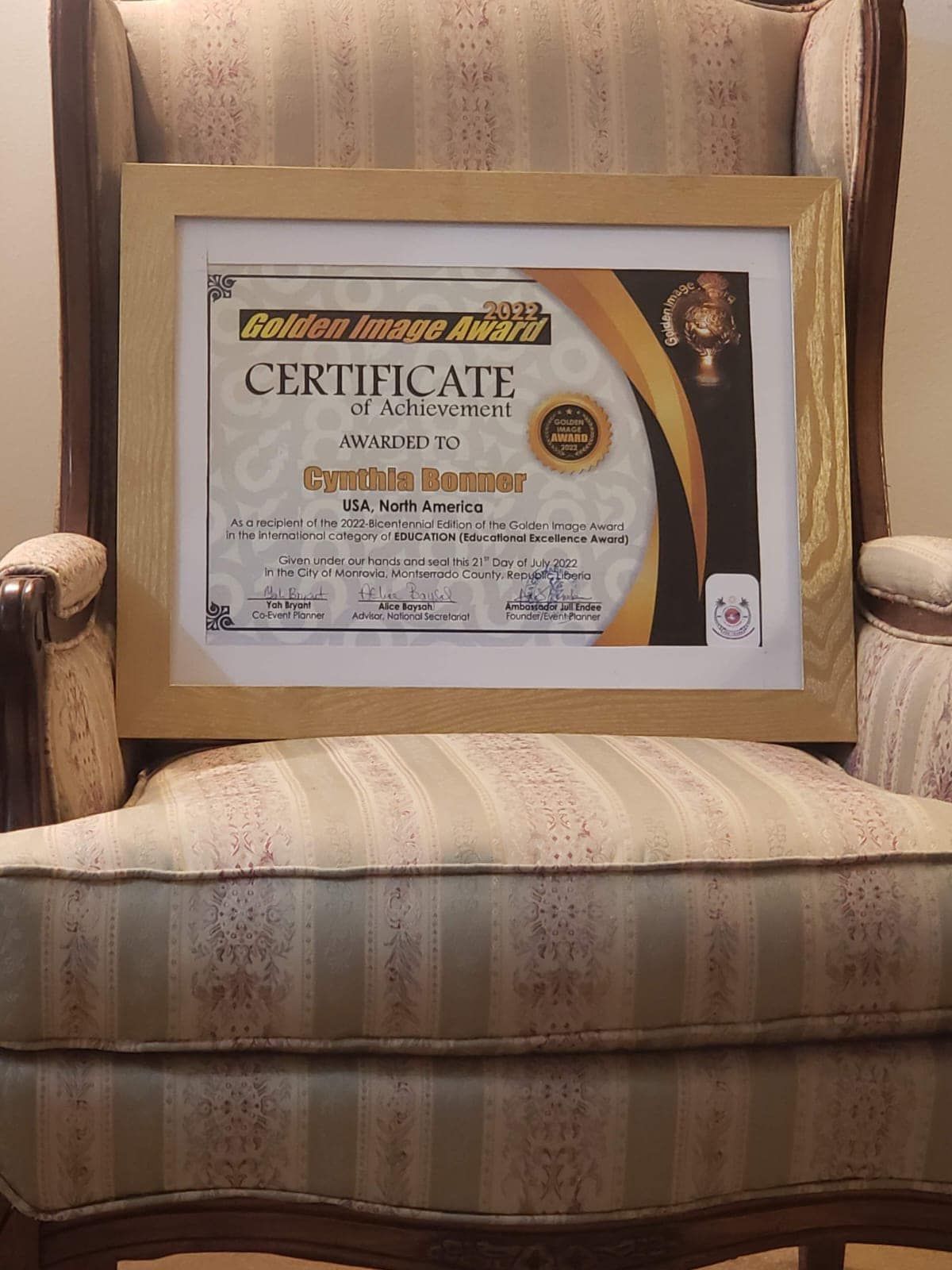 A framed certificate is sitting on top of a chair.