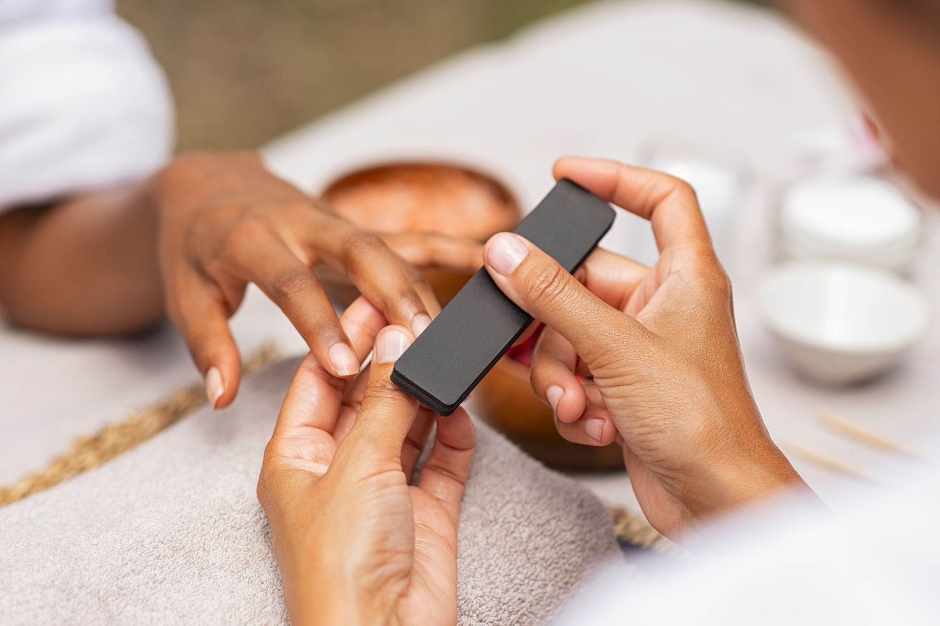 A woman is getting her nails done at a nail salon.