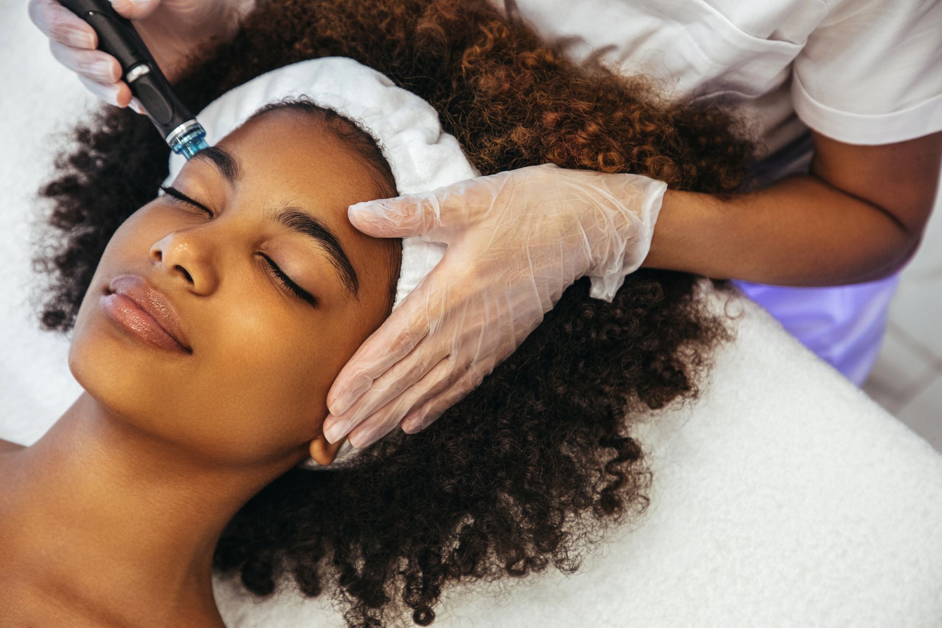 A woman is getting a facial treatment at a beauty salon.