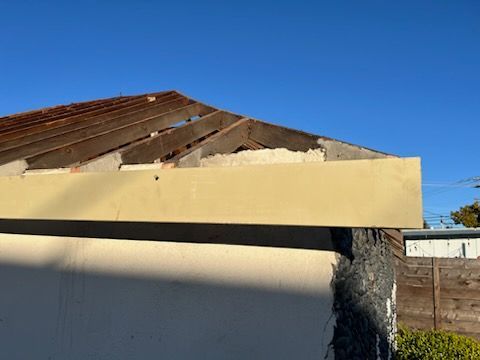 The roof of a building under construction or repair. Exposed wooden beams are visible