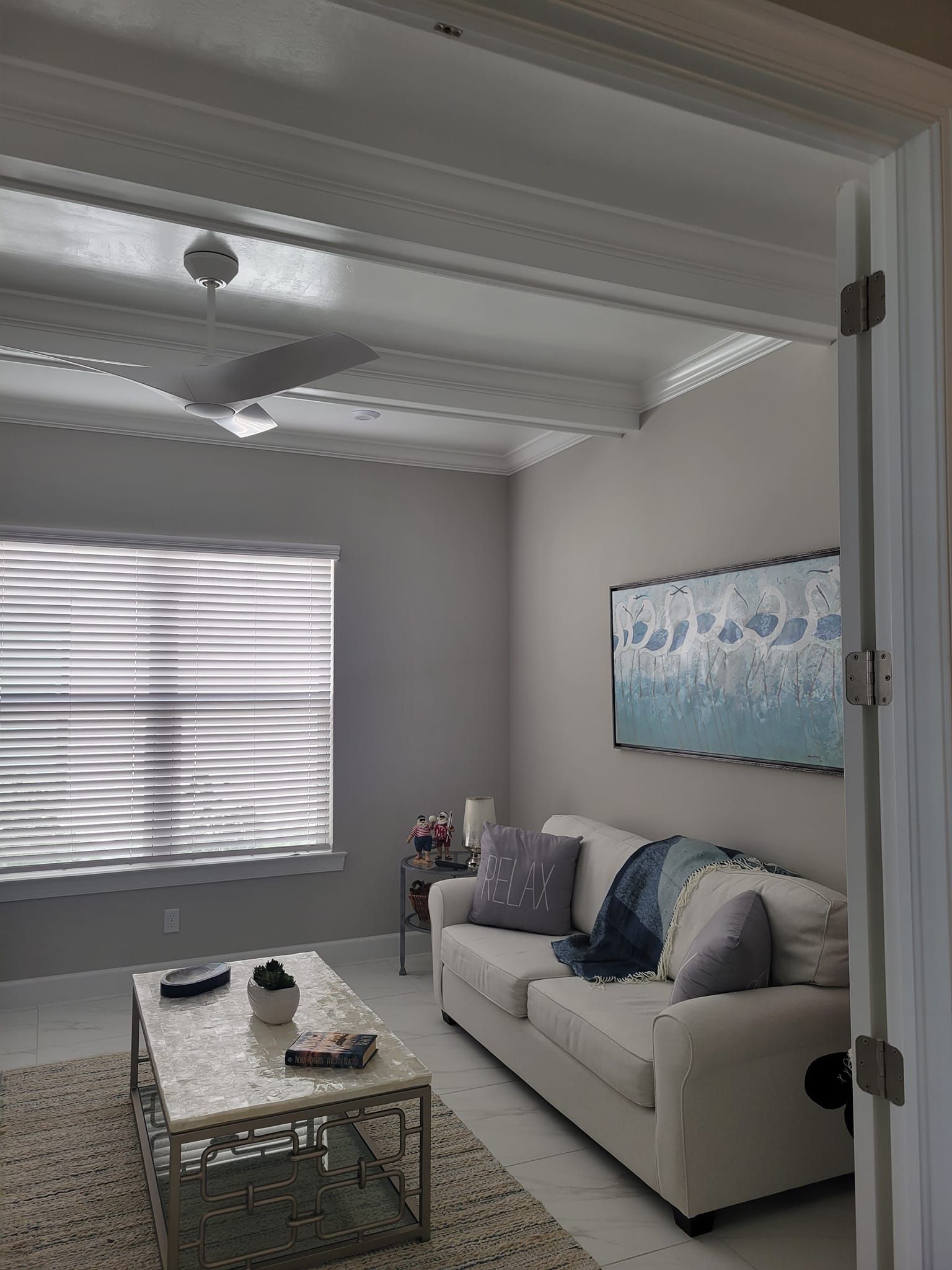 elegant room interior with sofa, center table, and ceiling fan