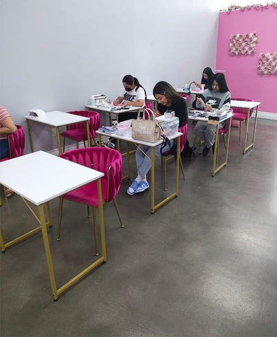 A group of people are sitting at tables in a classroom.
